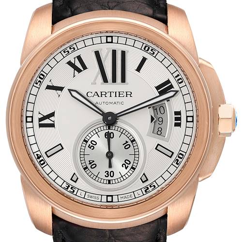 The image shows a front view of the Calibre de Cartier watch, displaying the dial, hands, sub-dial, and date window.