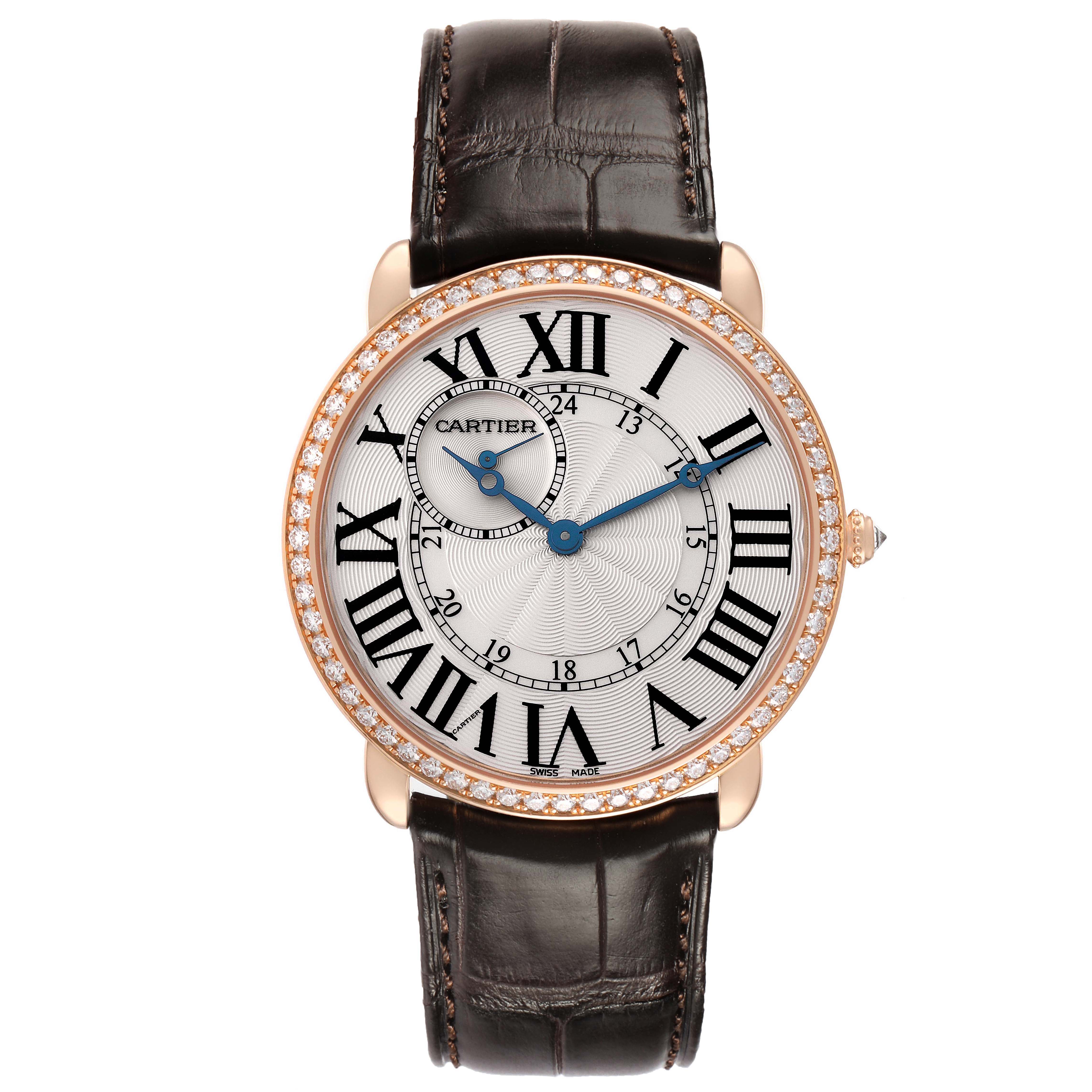 The Cartier Ronde WR007001 Men's Rose Gold Silver Dial watch is shown from a top view, highlighting its face, Roman numerals, blue hands, diamond bezel, and leather strap.