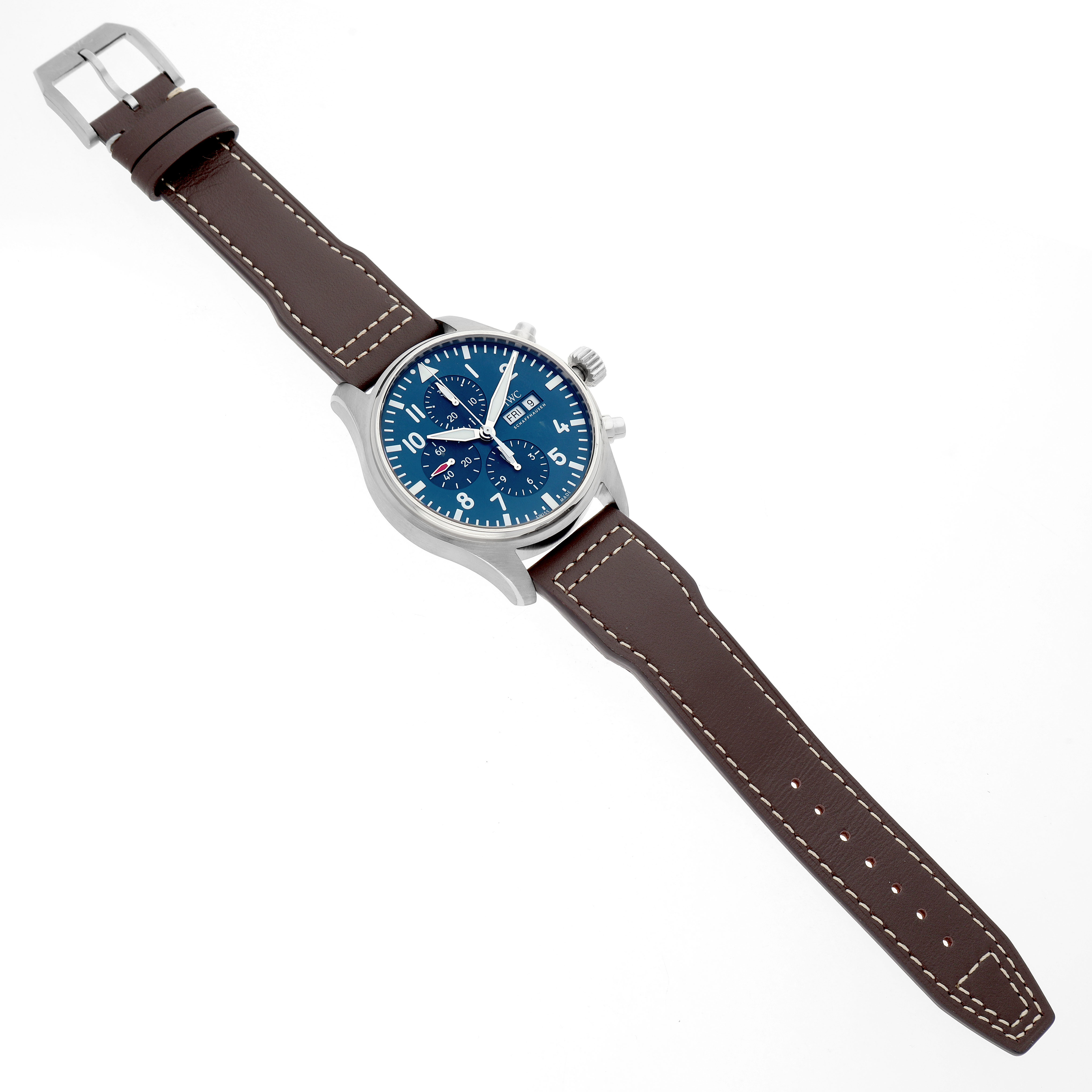 The IWC Pilot IW377714 Men's Stainless Steel Blue Dial watch is shown at a slight angle, displaying its face, case, crown, pushers, and brown leather strap with a buckle.