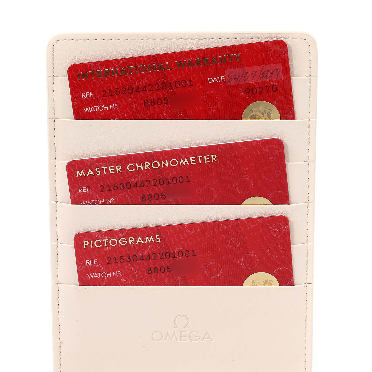 This image shows three red cards, including International Warranty, Master Chronometer, and Pictograms, in a white Omega holder for the Planet Ocean model.
