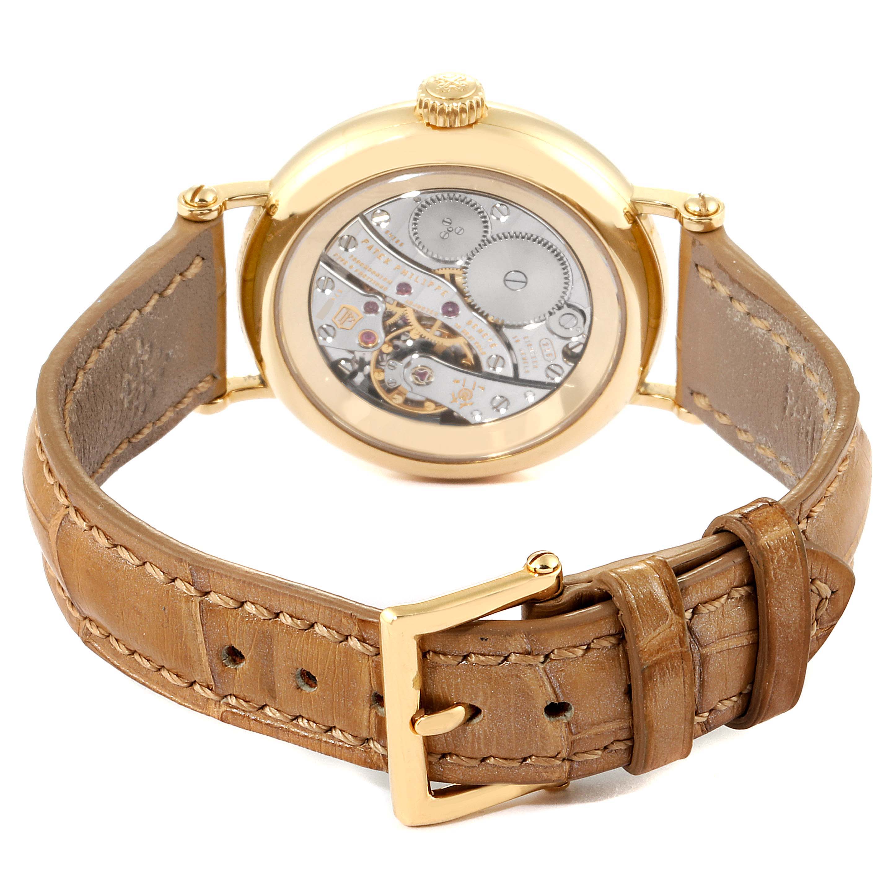 The image shows the rear view of the Patek Philippe Calatrava 7121J-001 Women's Yellow Gold Silver Dial 7121J-001 Women's Yellow Gold Silver Dial watch, displaying the movement mechanism and brown leather strap.