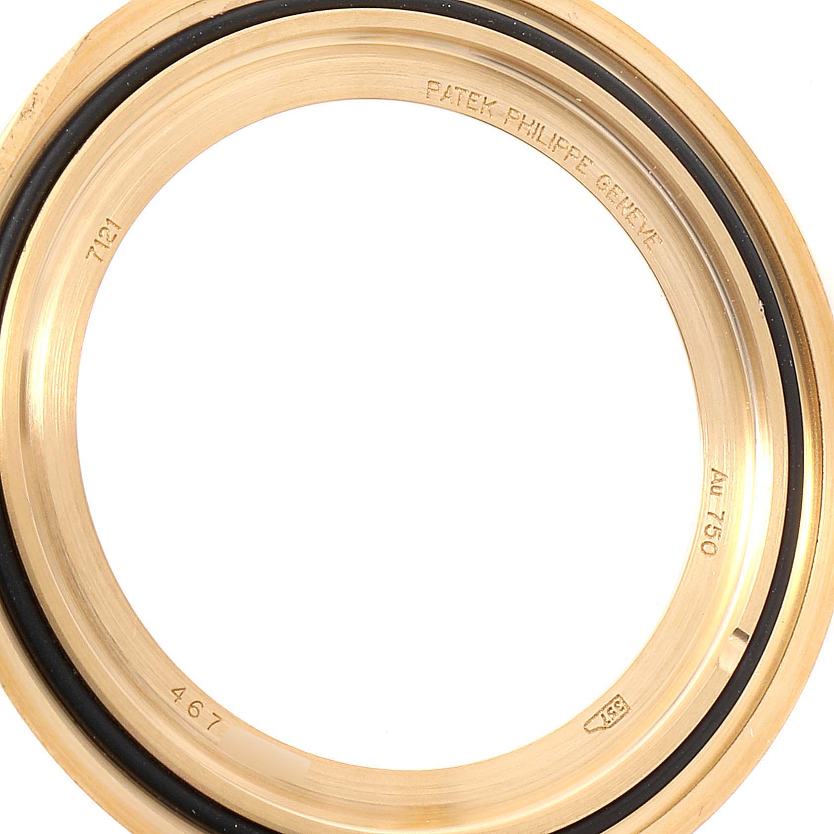 This image shows the bezel of a Patek Philippe Calatrava 7121J-001 Women's Yellow Gold Silver Dial 7121J-001 Women's Yellow Gold Silver Dial watch, displaying engraved serial numbers and hallmark stamps.