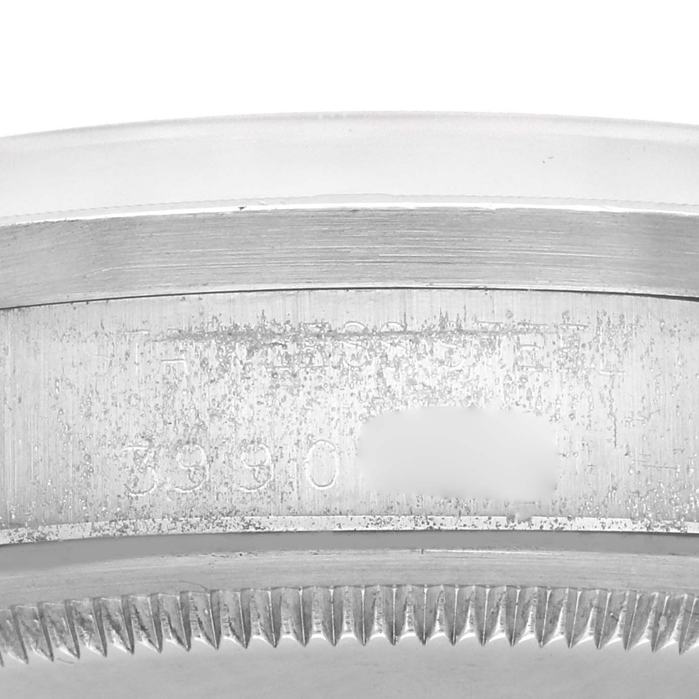 The image shows a close-up of the case side and serial number engraving on the Rolex Date watch.