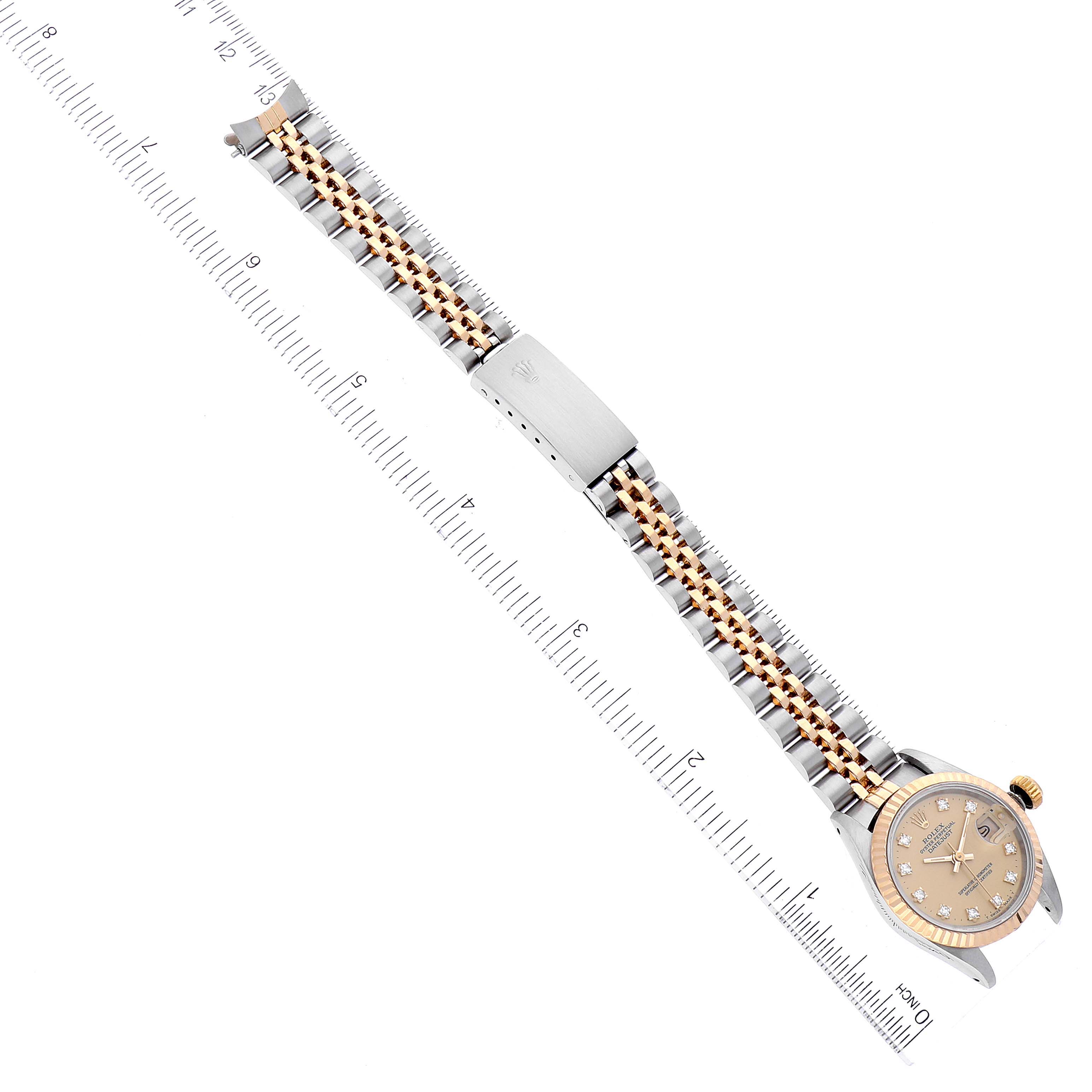 The image shows a Rolex Datejust 69173 Women's Steel and Gold (two tone) Champagne Dial 69173 Women's Steel and Gold (two tone) Champagne Dial watch from a top-down angle, highlighting its face, bracelet, and clasp, placed against a ruler.
