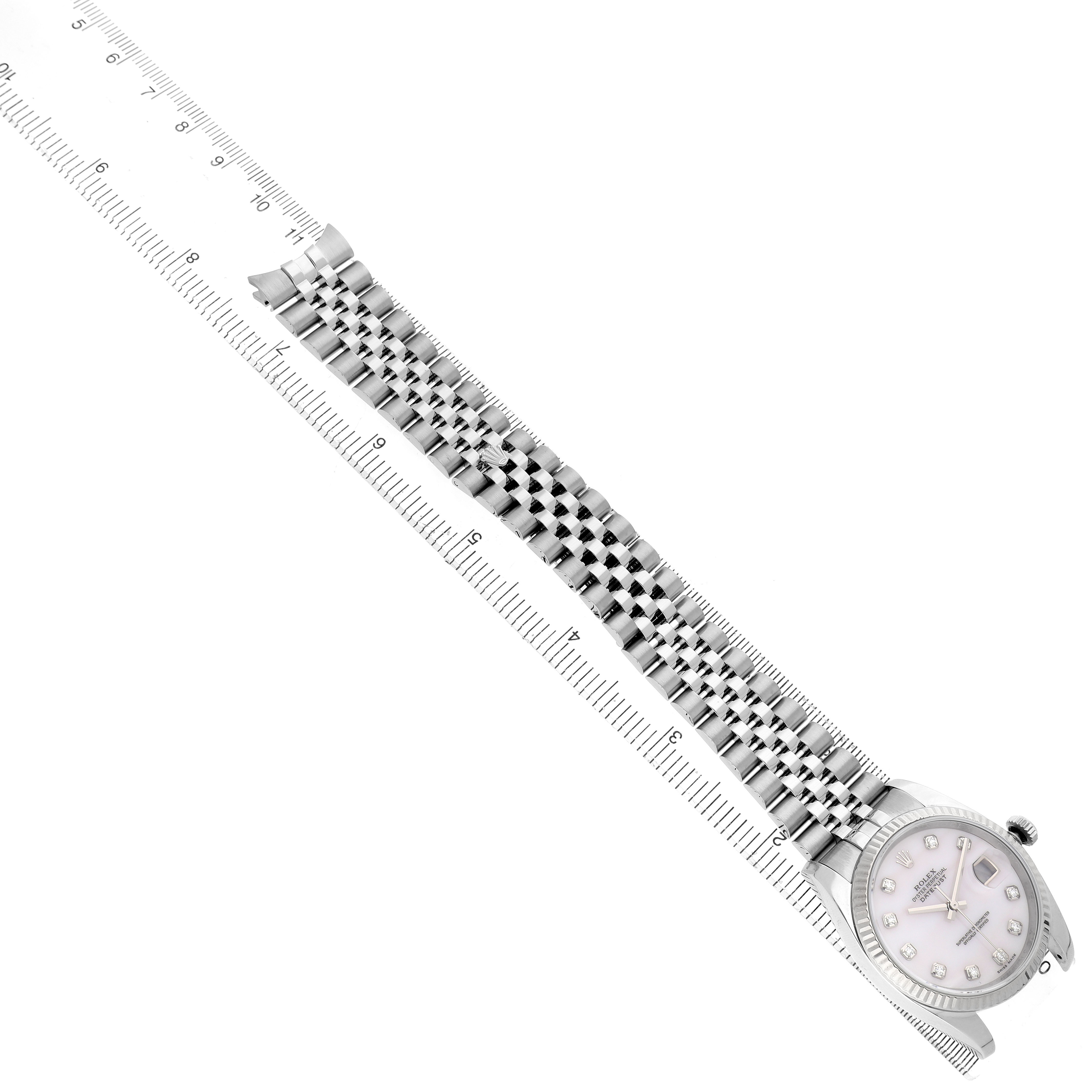 The Rolex Datejust 116234 Men's Stainless Steel Mother of Pearl Dial watch is shown at an angle, featuring its dial, case, and full bracelet alongside a ruler.