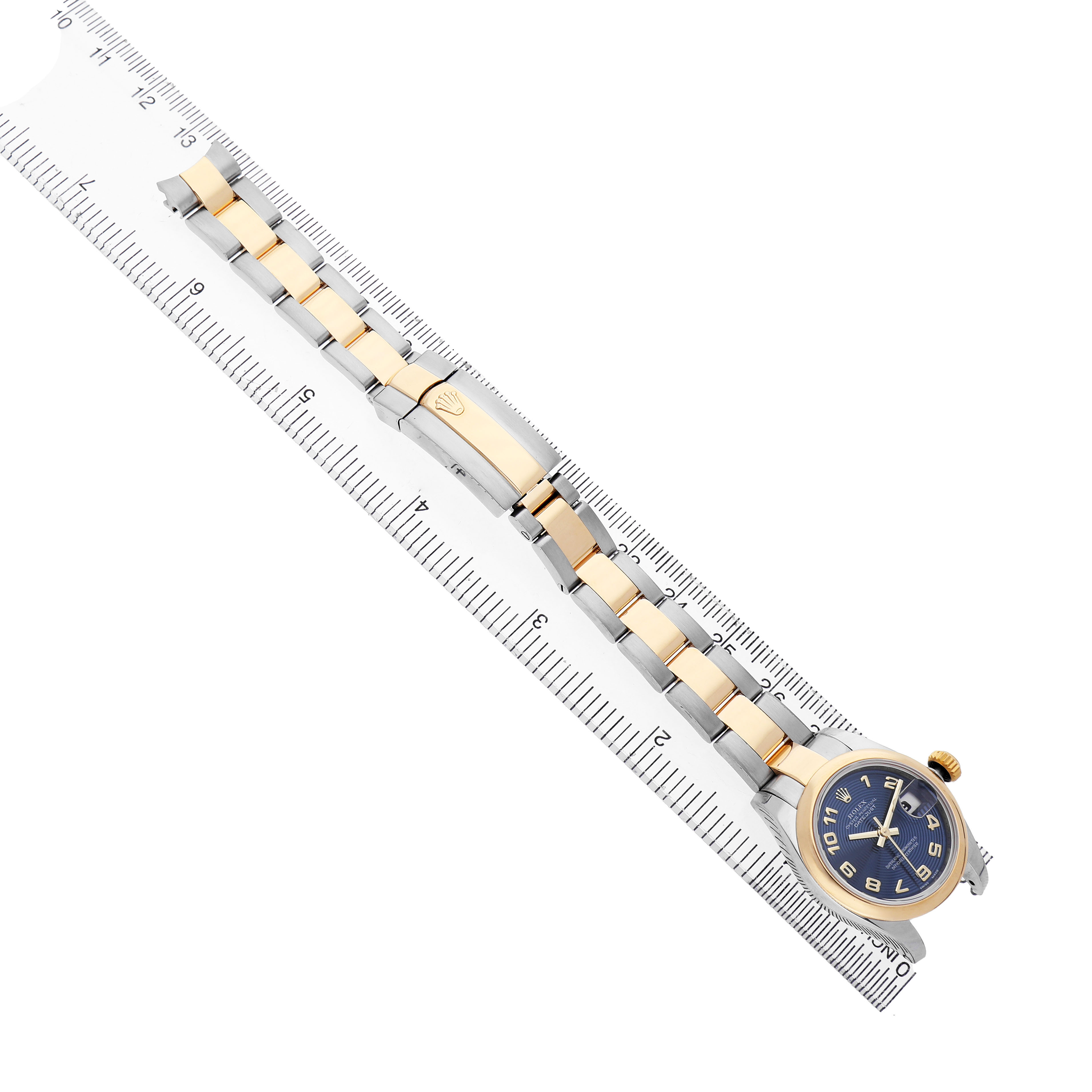 The Rolex Datejust 179163 Women's Steel and Gold (two tone) Blue Dial watch is shown in a side angle, highlighting the bracelet and clasp over a ruler for measurement.