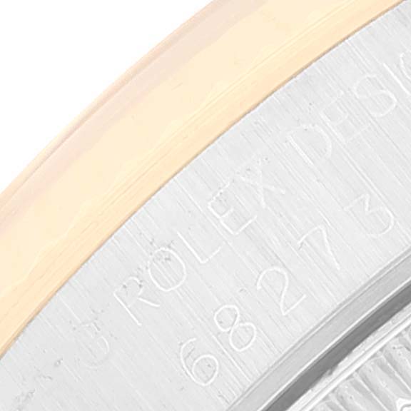 This image shows a close-up of the edge and engraved side of a Mid-Size Rolex watch.