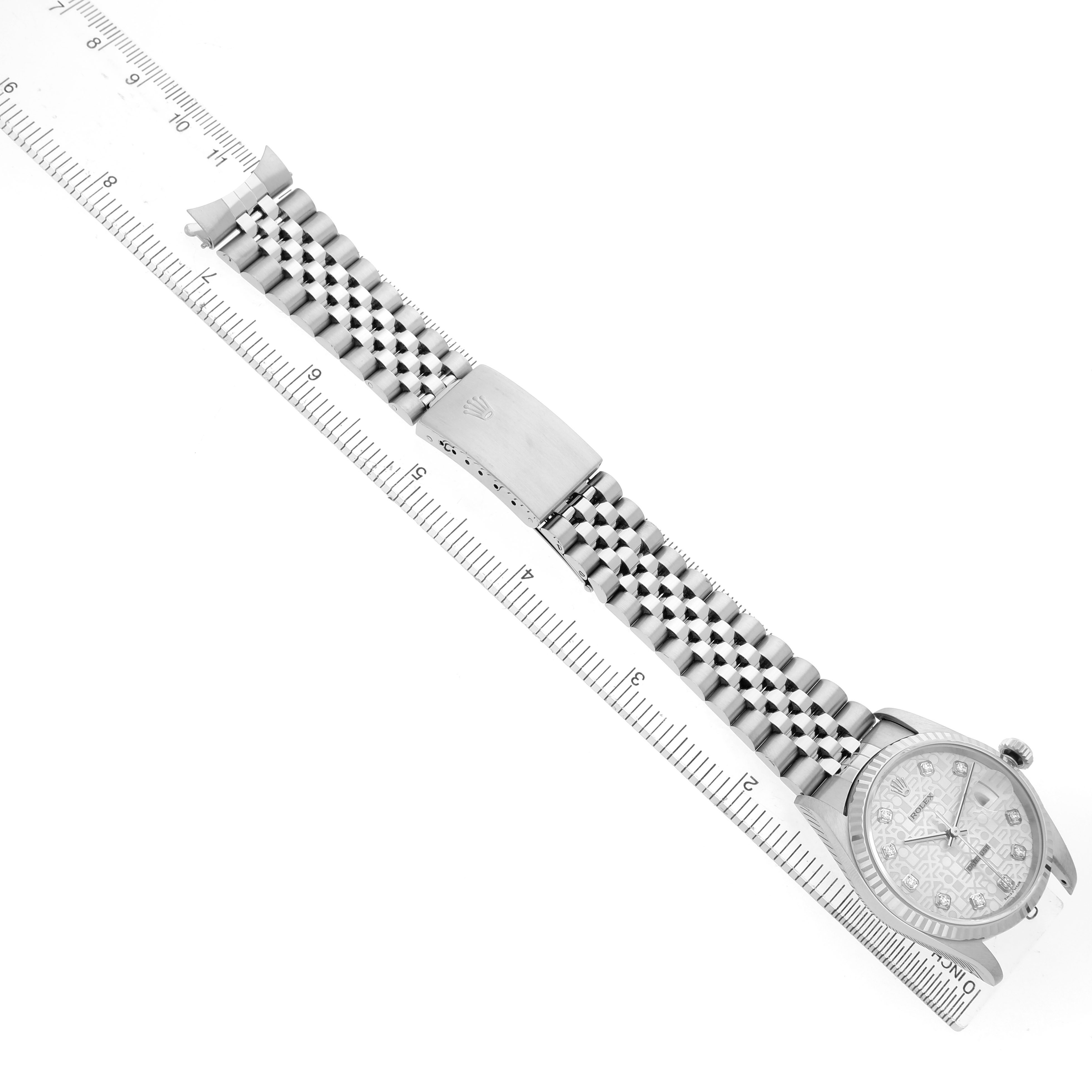 The Rolex Datejust 16234 Men's Stainless Steel Silver Dial watch is shown from a top-down angle, highlighting the face, bracelet, and clasp alongside a ruler.