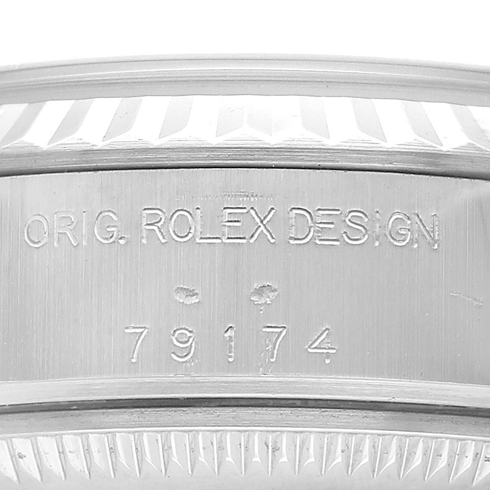 The image shows an engraving on the side of the case of a Rolex Datejust 79174 Women's Stainless Steel Blue Dial, displaying "ORIG. ROLEX DESIGN" and the model number "79174".