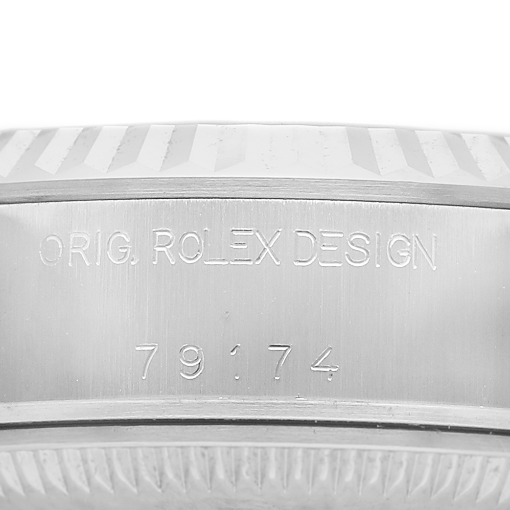 The image shows a close-up of the case side of a Rolex Datejust 179174 Women's Stainless Steel White Dial, featuring the engraving “ORIG. ROLEX DESIGN 79174.”