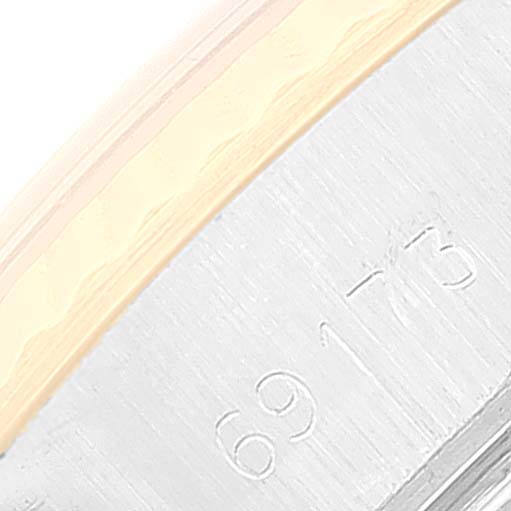 This close-up image shows the side of a Rolex Datejust 69173 Women's Steel and Gold (two tone) White Dial 69173 Women's Steel and Gold (two tone) White Dial watch with part of its bezel and the engraved serial number.