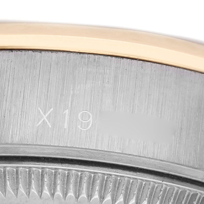 The image shows a close-up of the Rolex Datejust 69163 Women's Steel and Gold (two tone) Beige Dial watch, focusing on the edge of the bezel and the engraved serial number area.