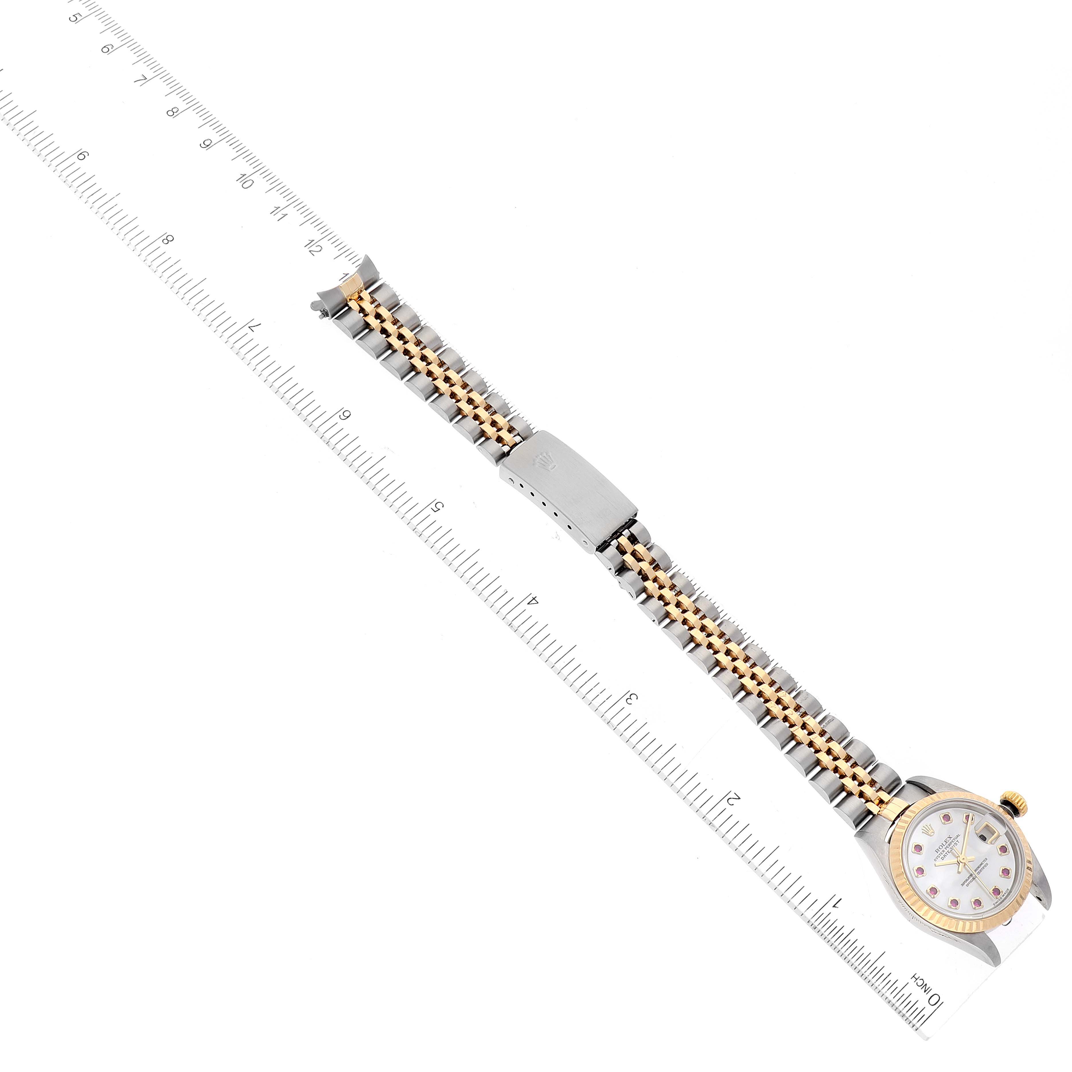 The image shows a Rolex Datejust 79173 Women
s Steel and Gold (two tone) Mother of Pearl Dial 79173 Women
s Steel and Gold (two tone) Mother of Pearl Dial watch laid flat with its entire bracelet visible alongside a measuring ruler.