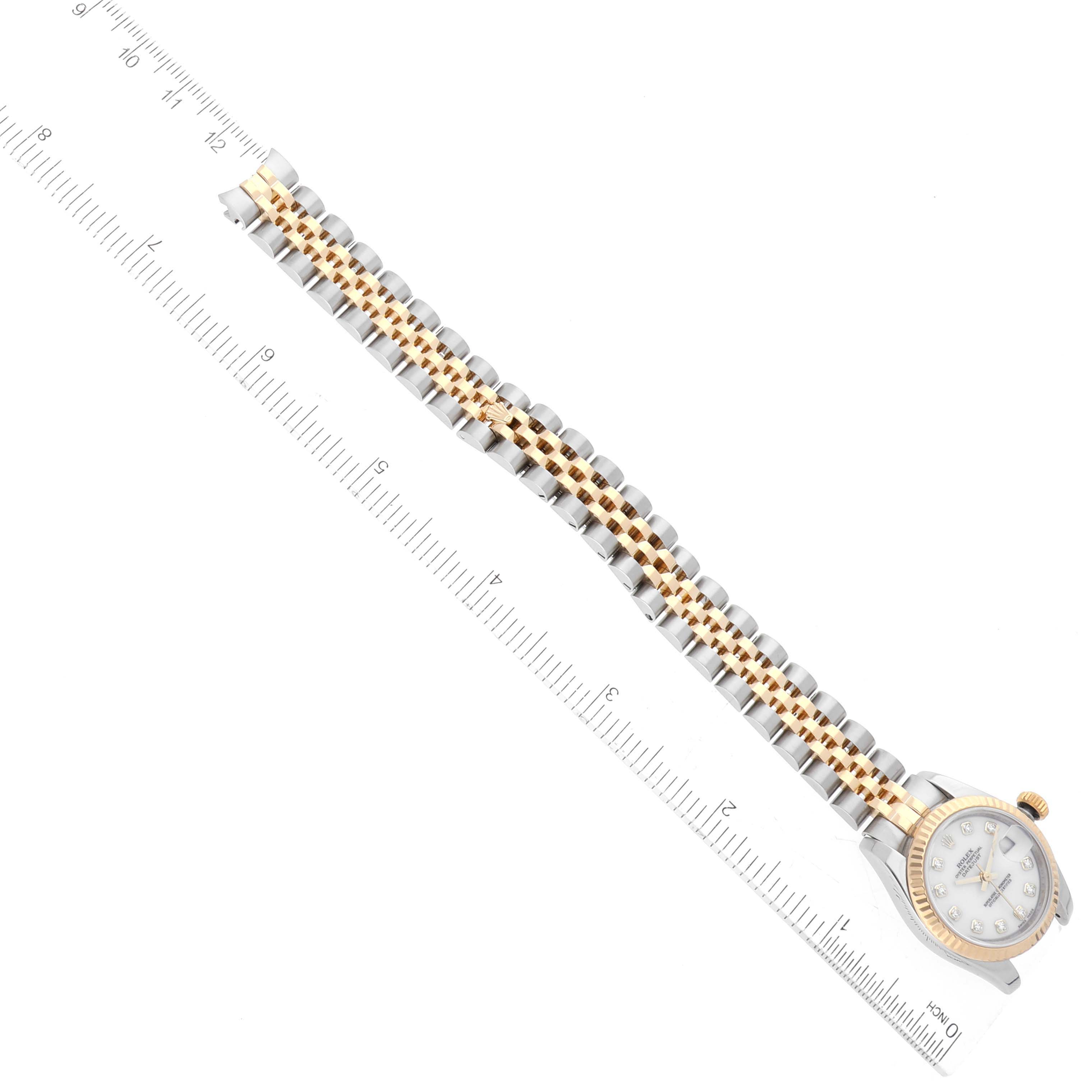 The Rolex Datejust 179173 Women's Steel and Gold (two tone) White Dial 179173 Women's Steel and Gold (two tone) White Dial watch is shown from a top view, highlighting the face, bezel, and two-tone bracelet, alongside a ruler for scale.