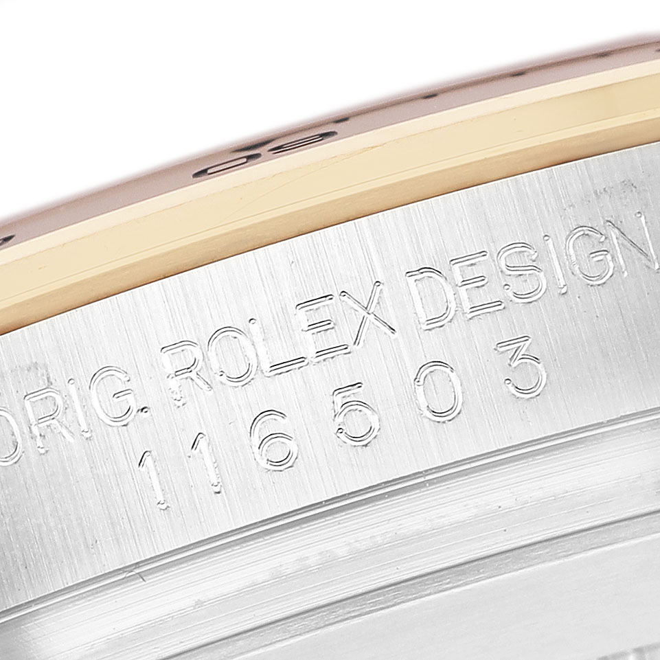 The image shows a close-up of the engraved case edge and bezel of the Rolex Daytona 116503 Men's Steel and Gold (two tone) White Dial.