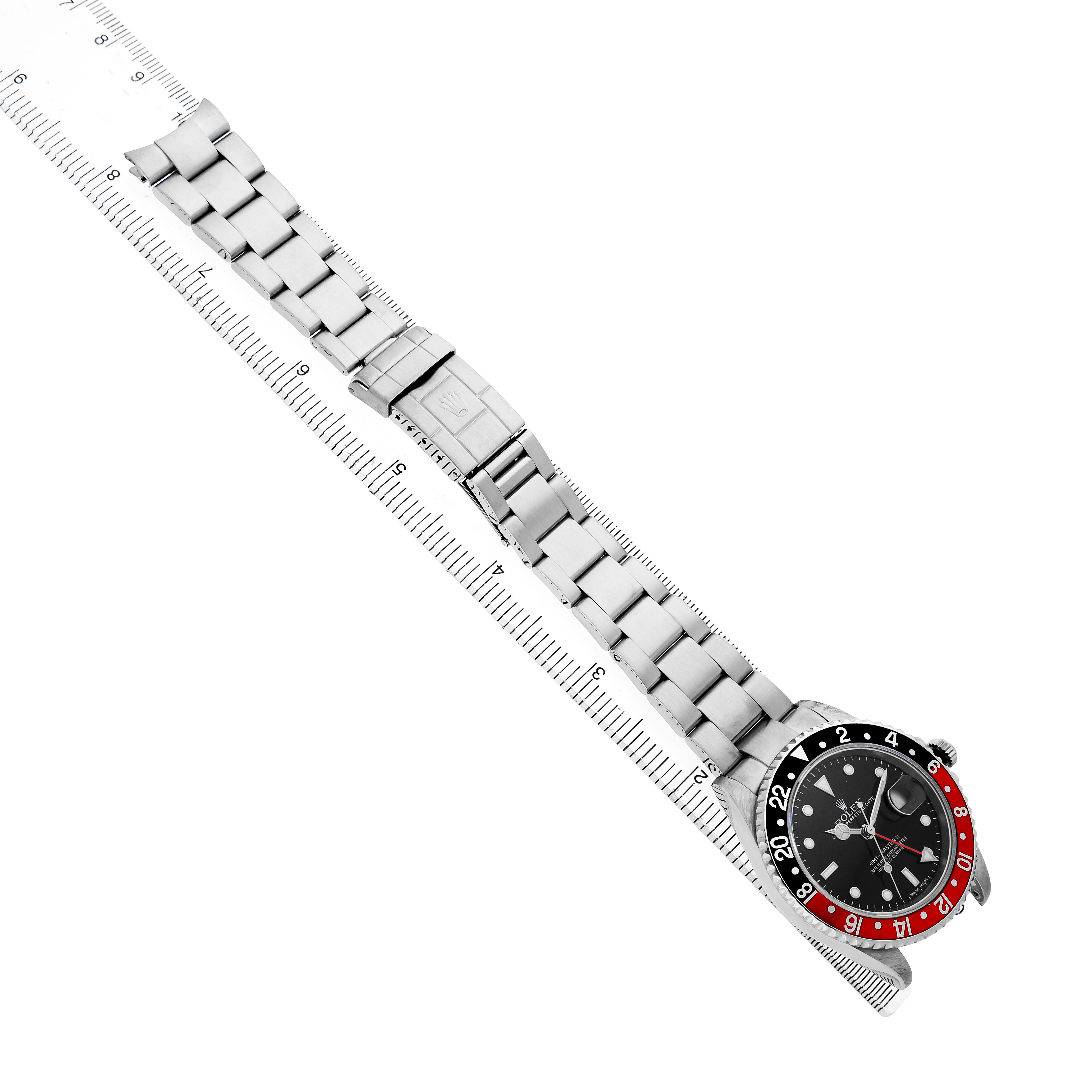 The Rolex GMT-Master 16710 Men's Stainless Steel Black Dial watch is shown at a diagonal angle, displaying the bezel, face, and full bracelet alongside a ruler.