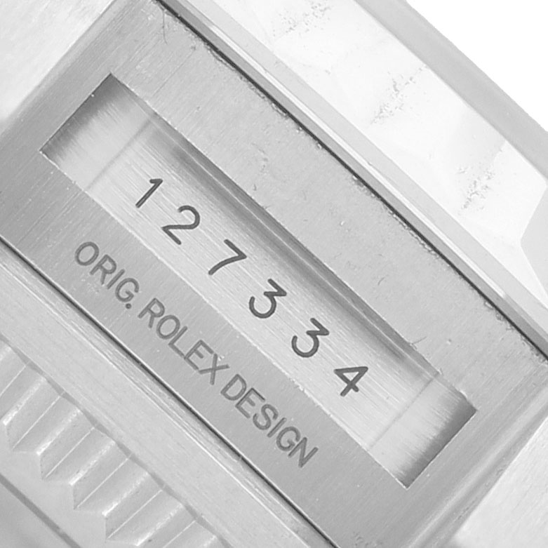 The image shows a close-up of the bracelet or clasp area of the Rolex Land‑Dweller 127334 Men's Stainless Steel White Dial, displaying the serial number.