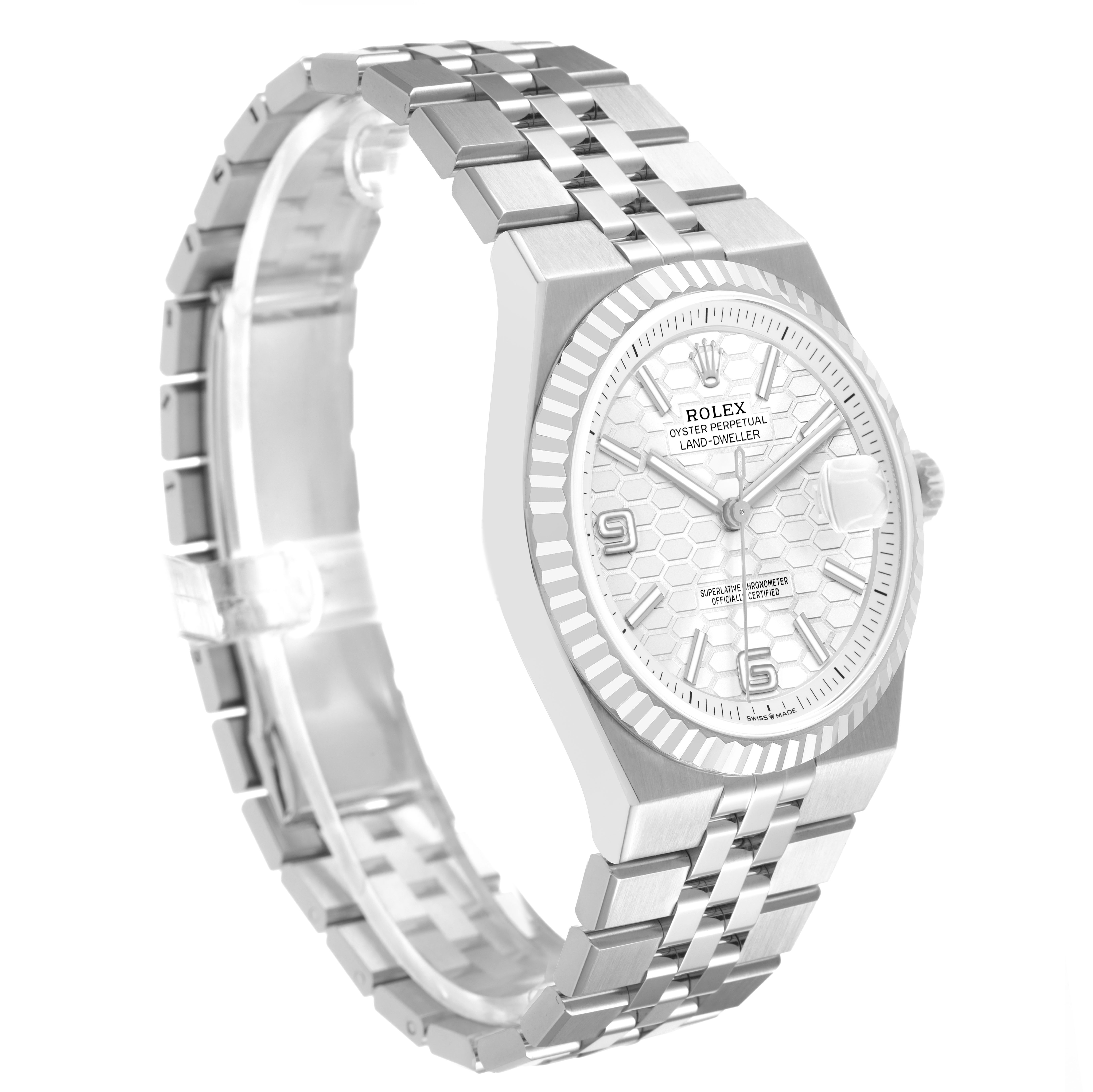 The Rolex Land-Dweller watch is shown at a three-quarter angle, highlighting the face, bezel, and bracelet.