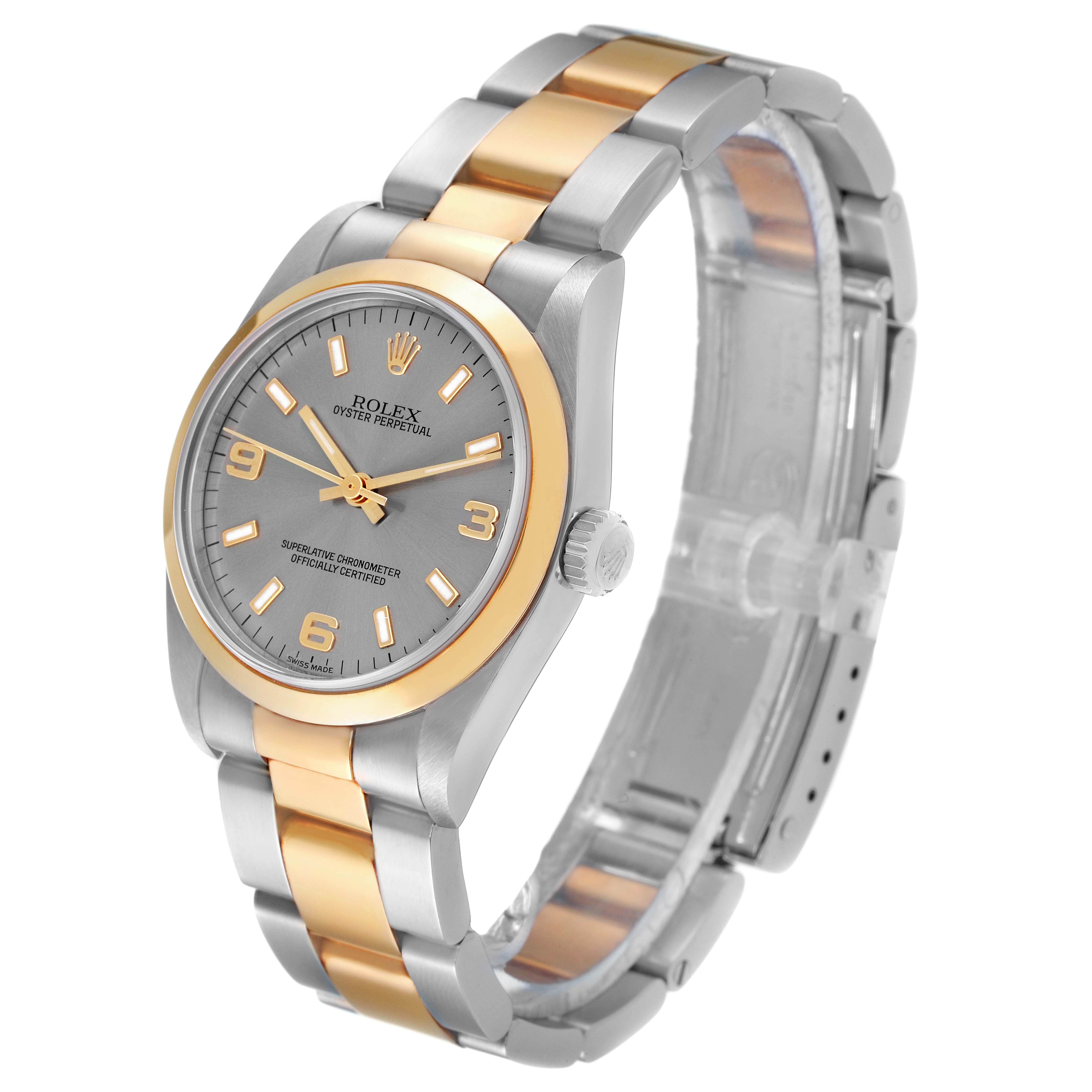 The image shows a Rolex Mid-Size 77483 Women
s Steel and Gold (two tone) Grey Dial 77483 Women
s Steel and Gold (two tone) Grey Dial Oyster Perpetual watch from an angled perspective highlighting the face, bracelet, and crown.