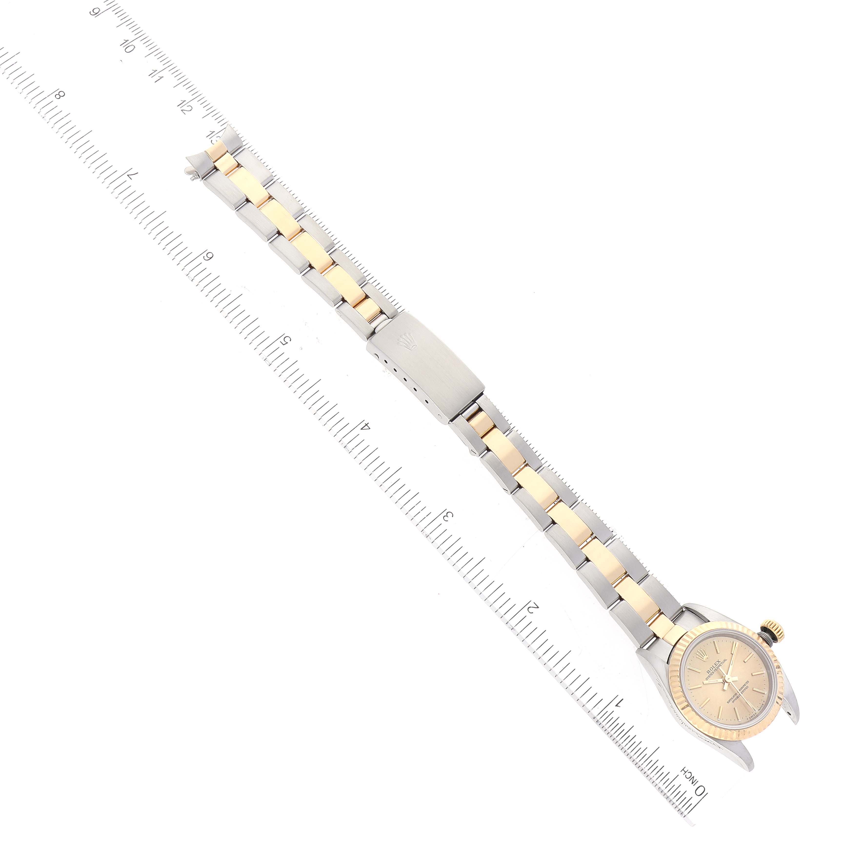 The image shows an aerial view of a Rolex Oyster Perpetual 67193 Women
s Steel and Gold (two tone) Champagne Dial 67193 Women
s Steel and Gold (two tone) Champagne Dial watch, highlighting the face, bracelet, and clasp.