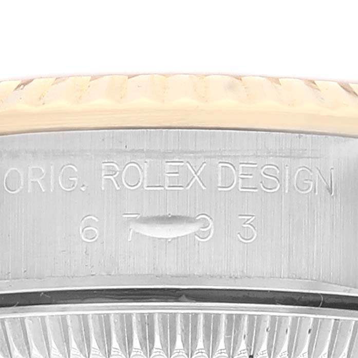 The image shows a close-up of the side view of the bezel and the engravings on the case of a Rolex Oyster Perpetual 67193 Women
s Steel and Gold (two tone) Champagne Dial 67193 Women
s Steel and Gold (two tone) Champagne Dial watch.