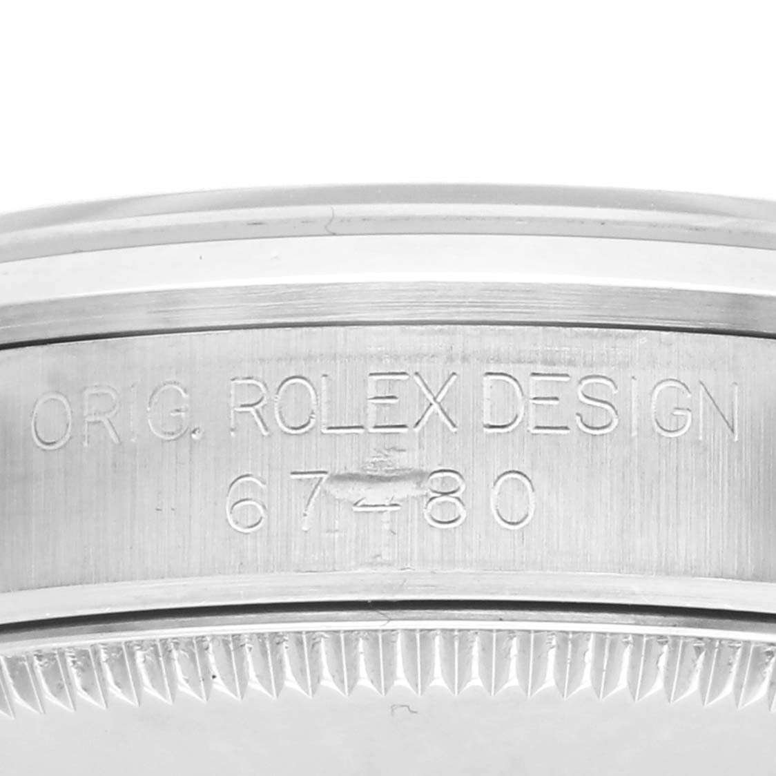 This image shows the side view of a Rolex Mid-Size 67480 Women's Stainless Steel Black Dial 67480 Women's Stainless Steel Black Dial model, focusing on the engraved serial number and design details on the case.