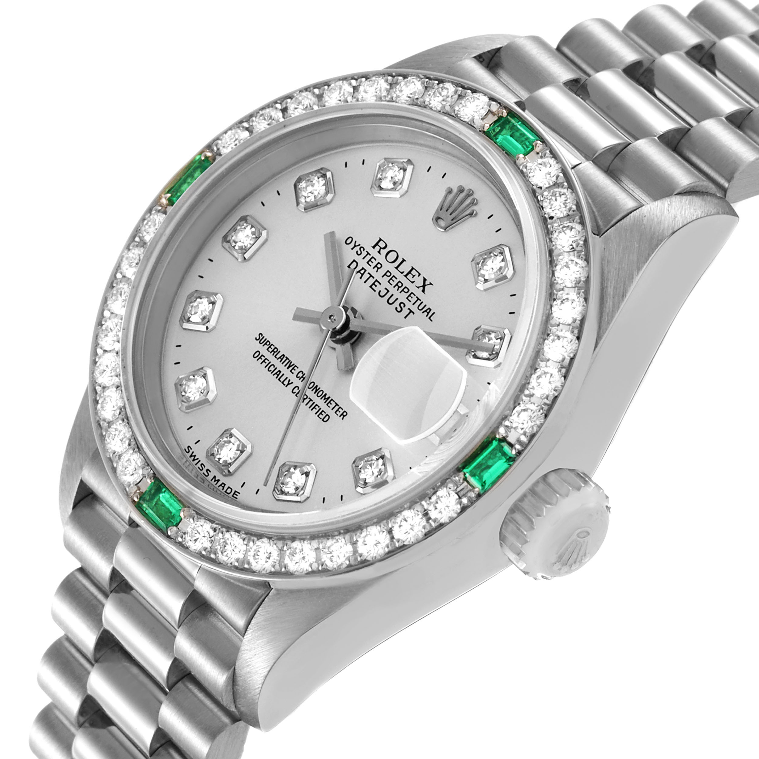 The Rolex President 79079 Women's White Gold Silver Dial watch is shown at a slight angle, highlighting the diamond and emerald bezel, dial, and part of the bracelet.