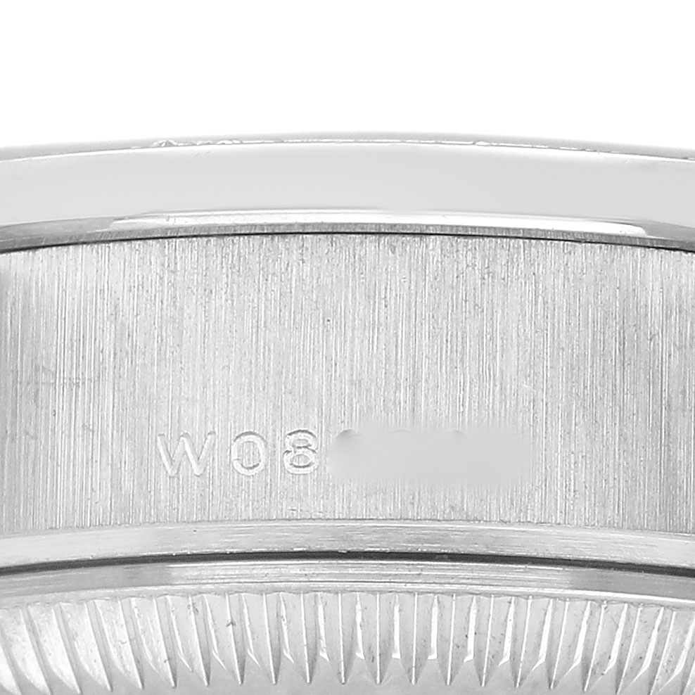 The image shows a close-up of the side of a Rolex President 79079 Women's White Gold Silver Dial watch, highlighting the brushed metal surface and engraved details.