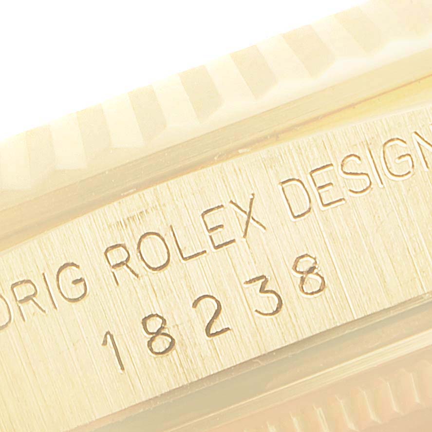 This image shows a close-up of the engraving on the side of a Rolex President 18238 Men's Yellow Gold Champagne Dial 18238 Men's Yellow Gold Champagne Dial model watch, including the text "ORIG ROLEX DESIGN" and the model number "18238."