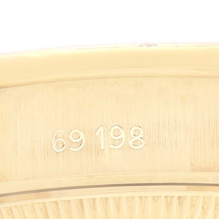 This image shows the side of a Rolex President 69198 Women
s Yellow Gold Champagne Dial 69198 Women
s Yellow Gold Champagne Dial model watch with the serial number "69198" engraved.