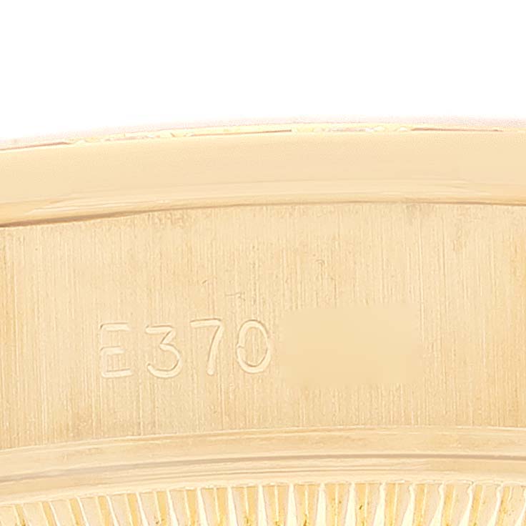 The close-up image shows the inner side of the bezel from a Rolex President 69198 Women
s Yellow Gold Champagne Dial 69198 Women
s Yellow Gold Champagne Dial model watch, featuring engraved serial numbers.