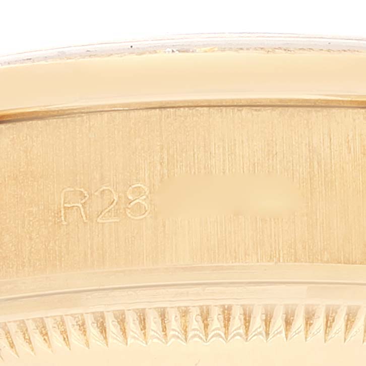 This image shows a close-up of the engraved serial number on the gold caseback of a Rolex President 69288 Women's Yellow Gold Brown Dial 69288 Women's Yellow Gold Brown Dial model watch.