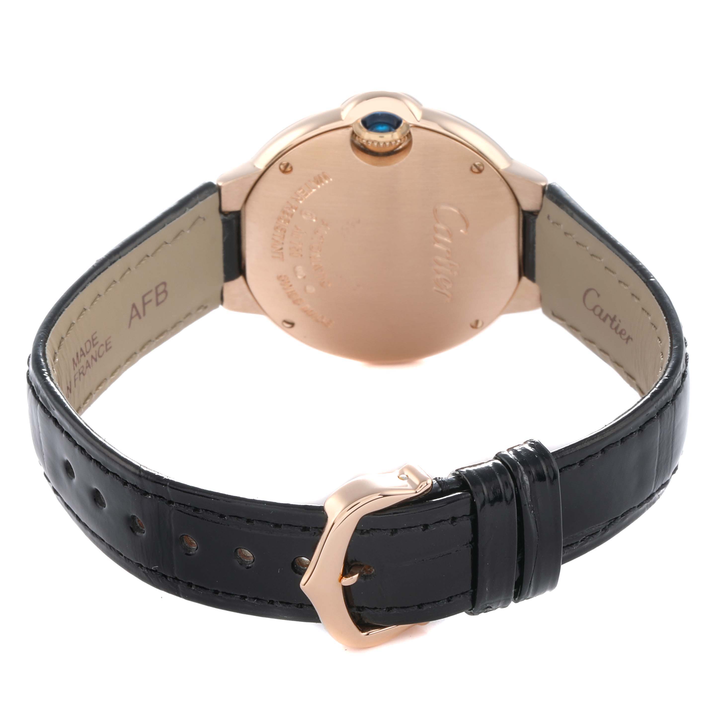 The image shows the back of a Cartier Ballon Bleu WE902063 Women
s Rose Gold Silver Dial watch, highlighting its case, crown, and black leather strap.