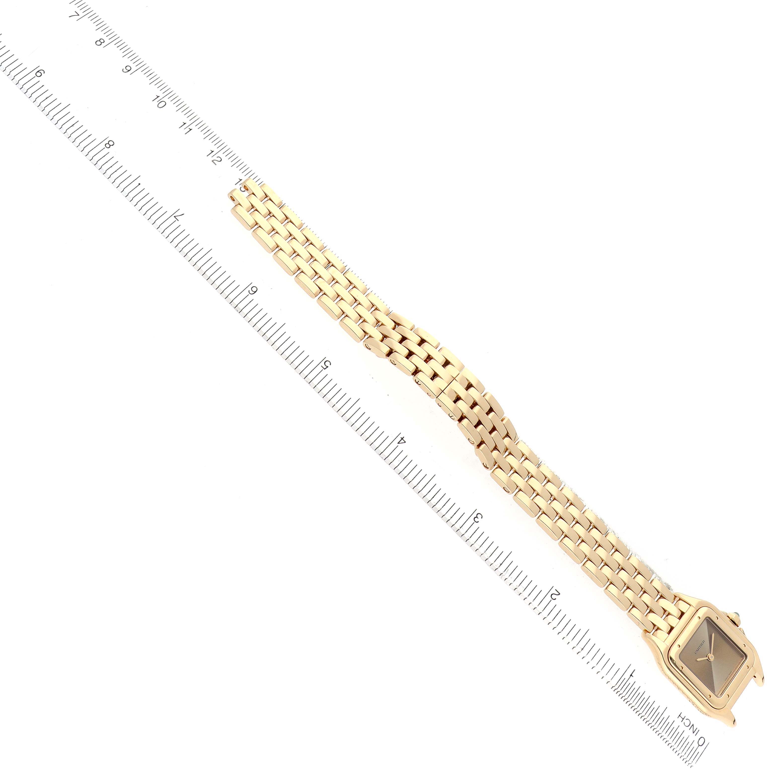 The Panthere de Cartier watch is shown from a top angle, highlighting the full bracelet and face alongside a ruler.