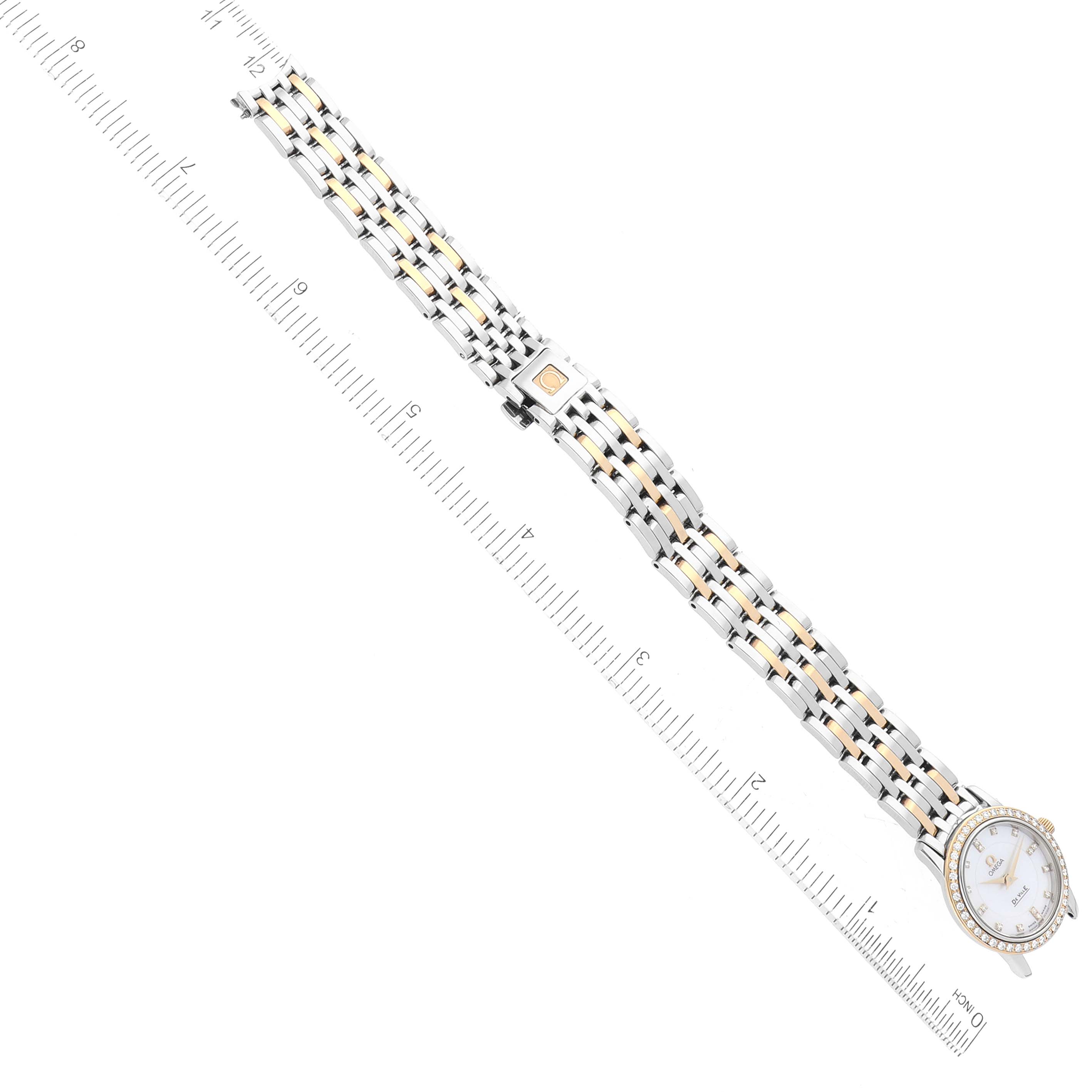 The Omega 4375.75.00 Women
s Steel and Gold (two tone) Mother of Pearl Dial 4375.75.00 Women
s Steel and Gold (two tone) Mother of Pearl Dial DeVille Mother Of Pearl Diamond Steel Yellow Gold Ladies Watch 4375.75.00 is shown laid flat with a ruler for scale.