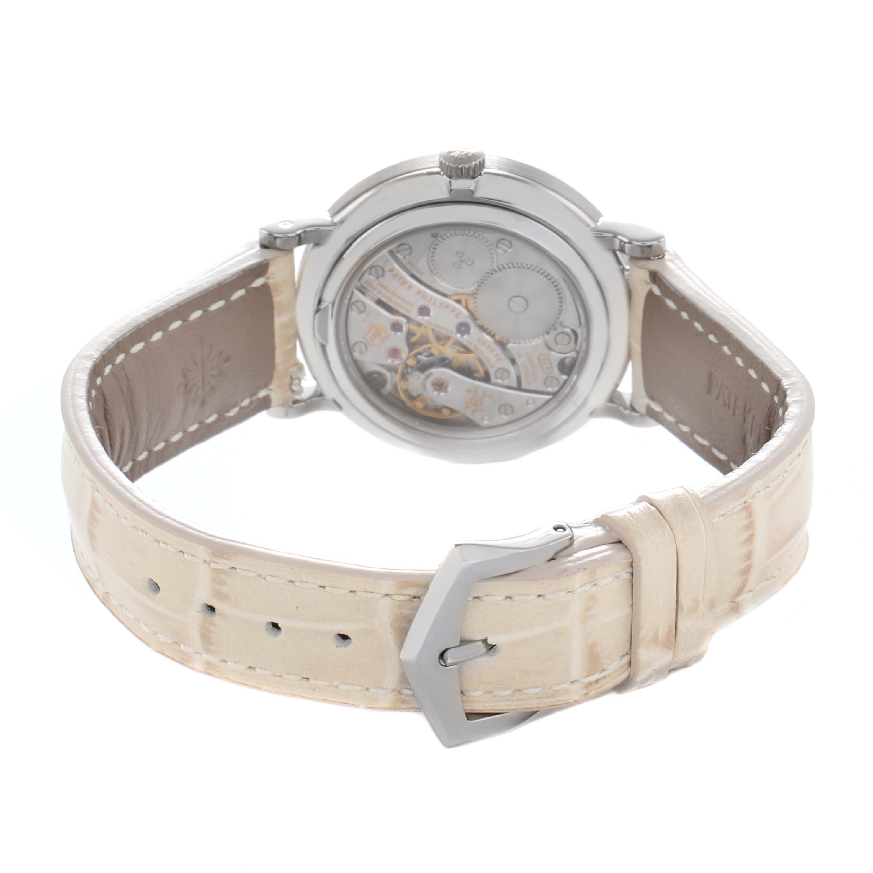 The image shows the back view of a Patek Philippe Calatrava 7120 Women
s White Gold Beige Dial watch, highlighting the movement through a transparent case back and the leather strap.