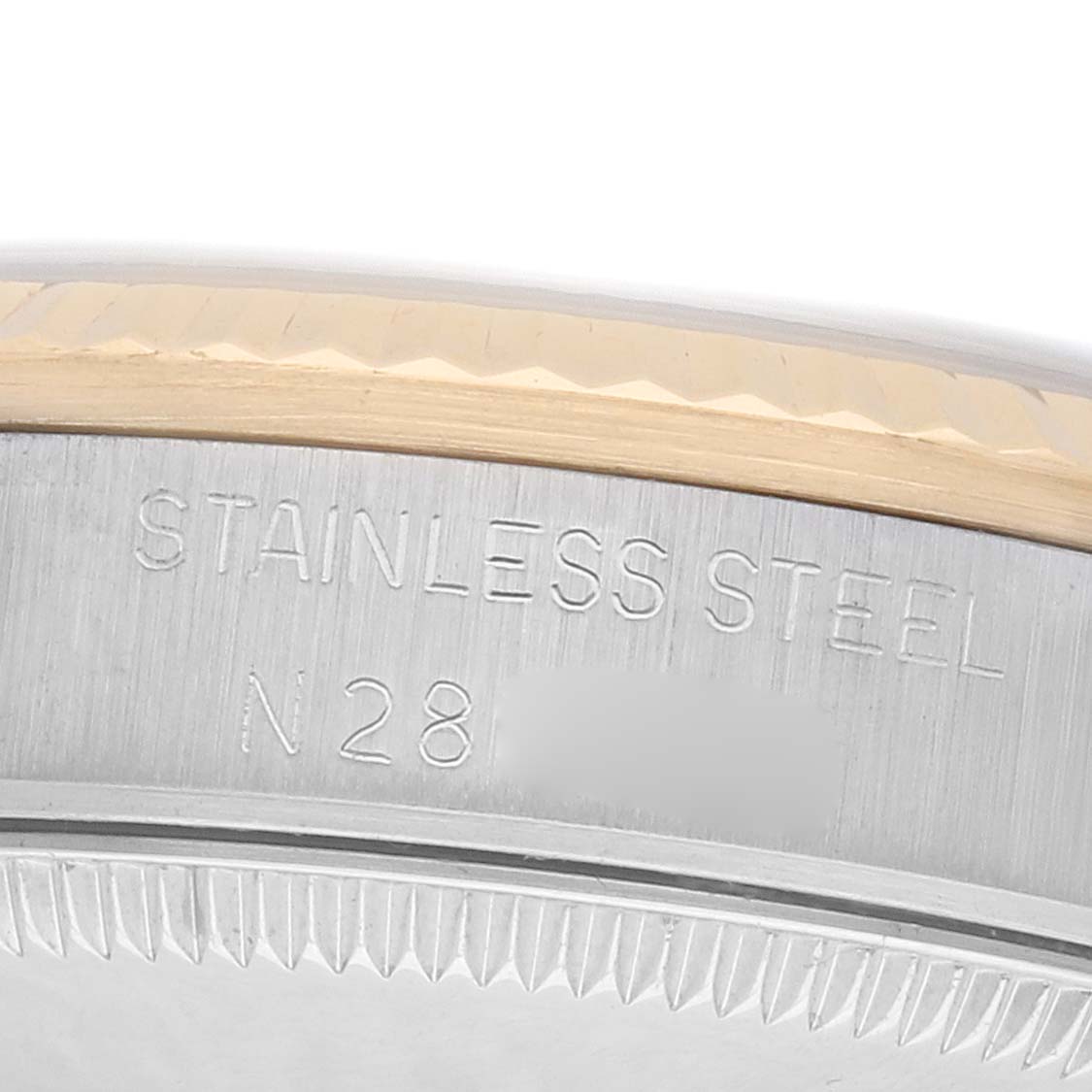 The image shows a close-up of the side of a Rolex Mid-Size 68273 Women
s Steel and Gold (two tone) White Dial watch, highlighting the stainless steel edge and engravings.