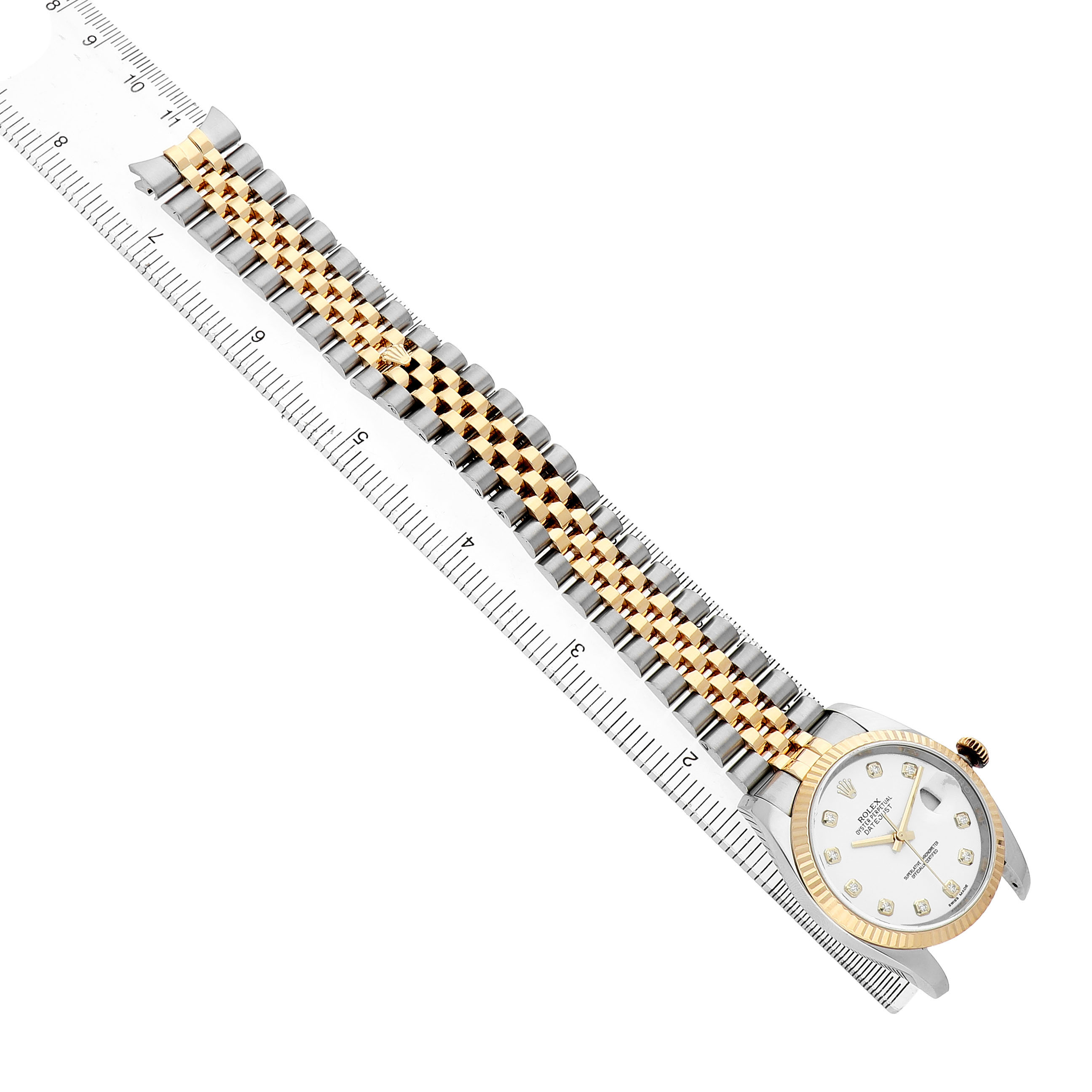 The Rolex Datejust 116233 Men's Steel and Gold (two tone) White Dial watch is shown from a top-down angle, highlighting the face, bezel, and two-tone bracelet aligned with a ruler.