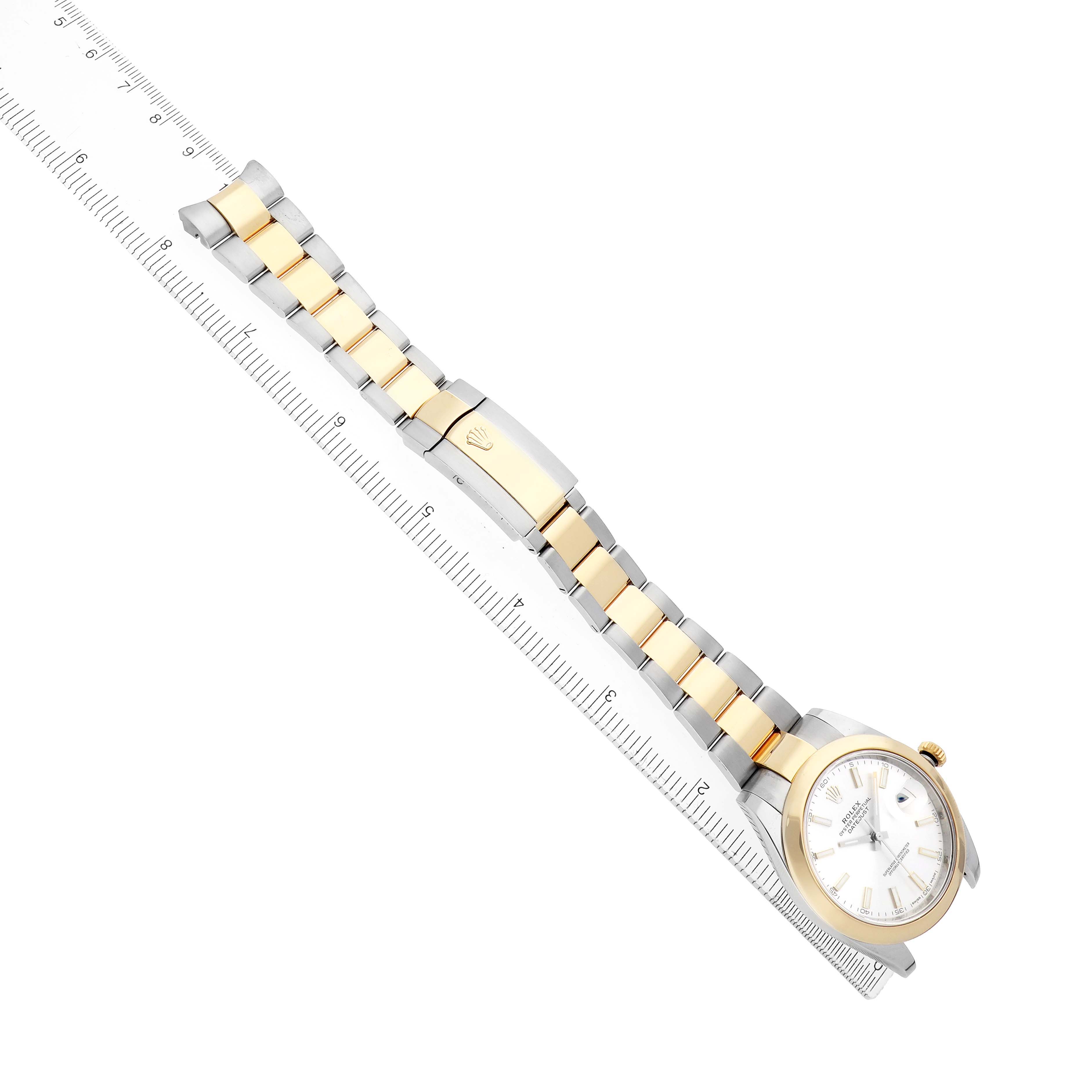 The Rolex Datejust 41 126303 Men
s Steel and Gold (two tone) Silver Dial is shown at an angled top view, displaying the face, two-tone bracelet, and clasp alongside a ruler.