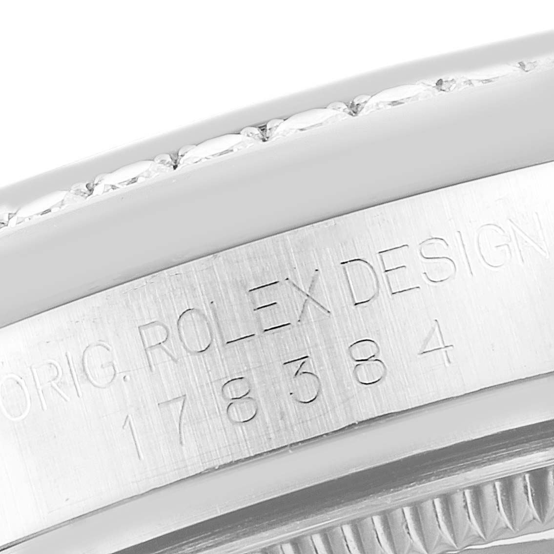 The image shows a close-up of the engraved side of a Rolex Mid-Size 178384 Women
s Stainless Steel Brown Dial watch, highlighting the bezel and case details.