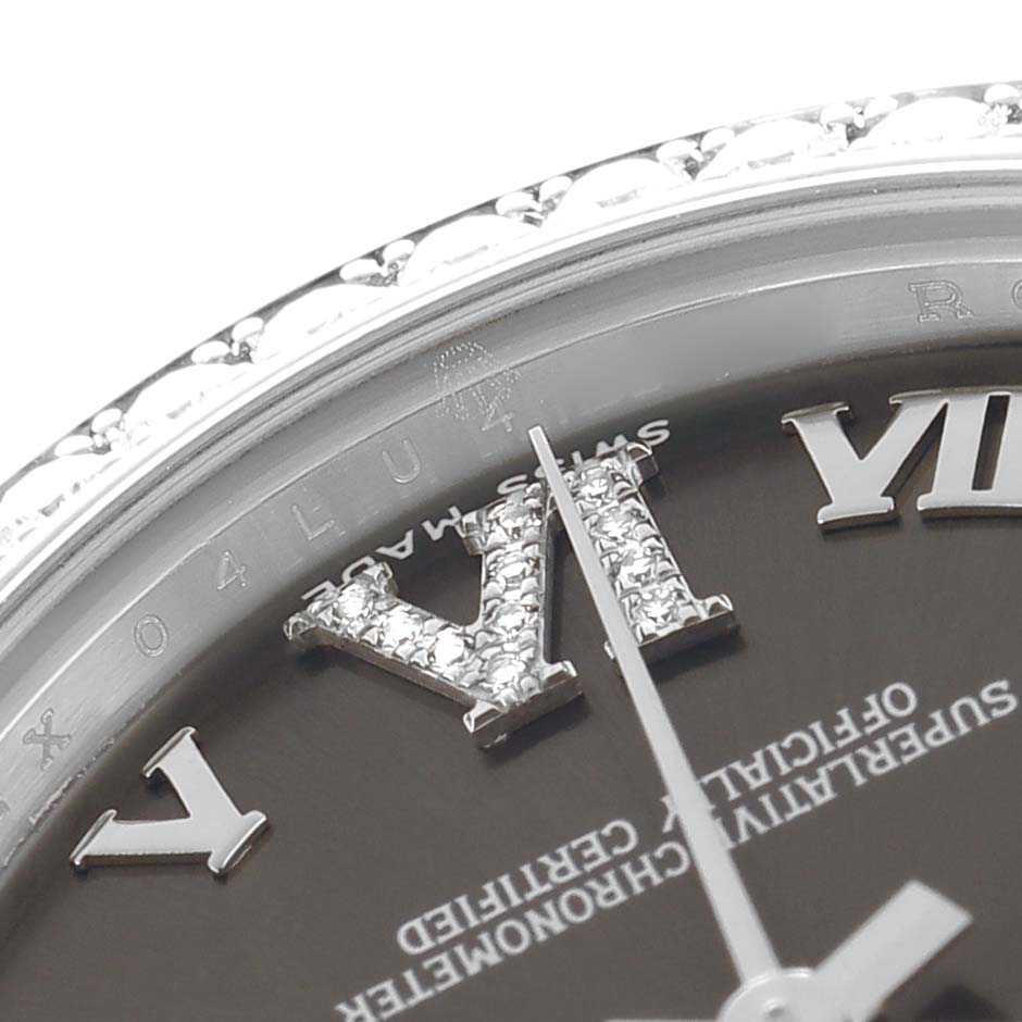 The image shows a close-up of the dial and bezel of a mid-size Rolex watch, highlighting Roman numerals and part of the bezel design.