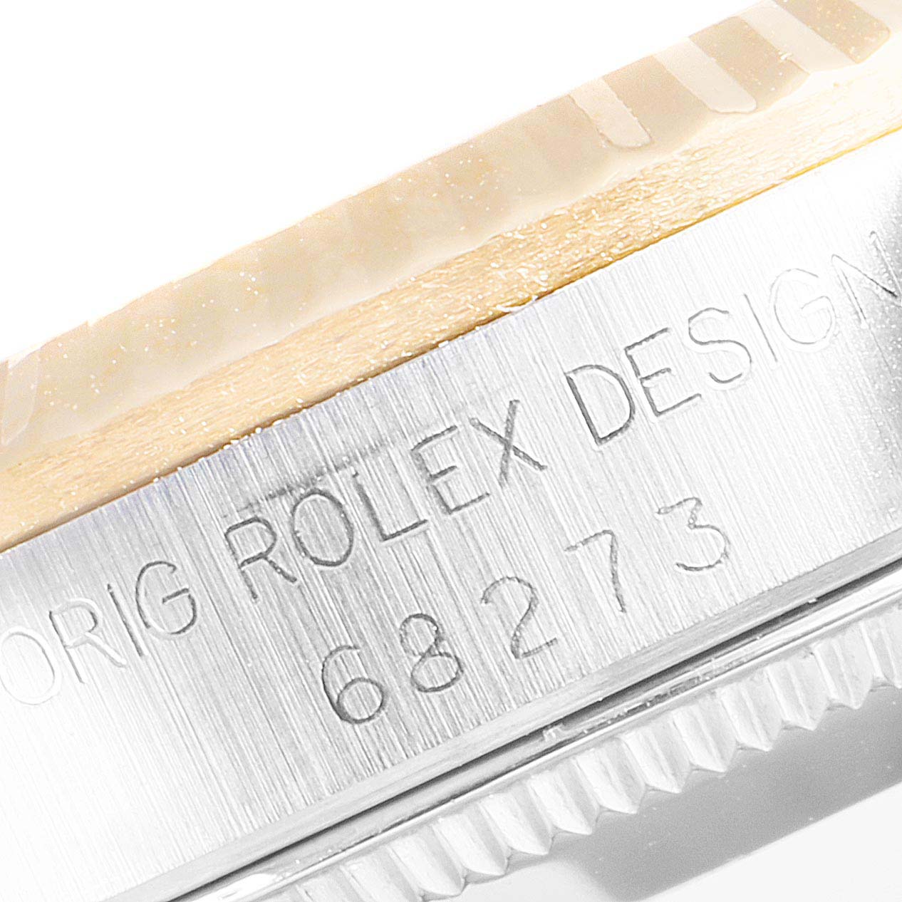 The image shows a close-up of the side engraving and bezel of a Rolex Mid-Size 68273 Women
s Steel and Gold (two tone) Champagne Dial 68273 Women
s Steel and Gold (two tone) Champagne Dial model watch.