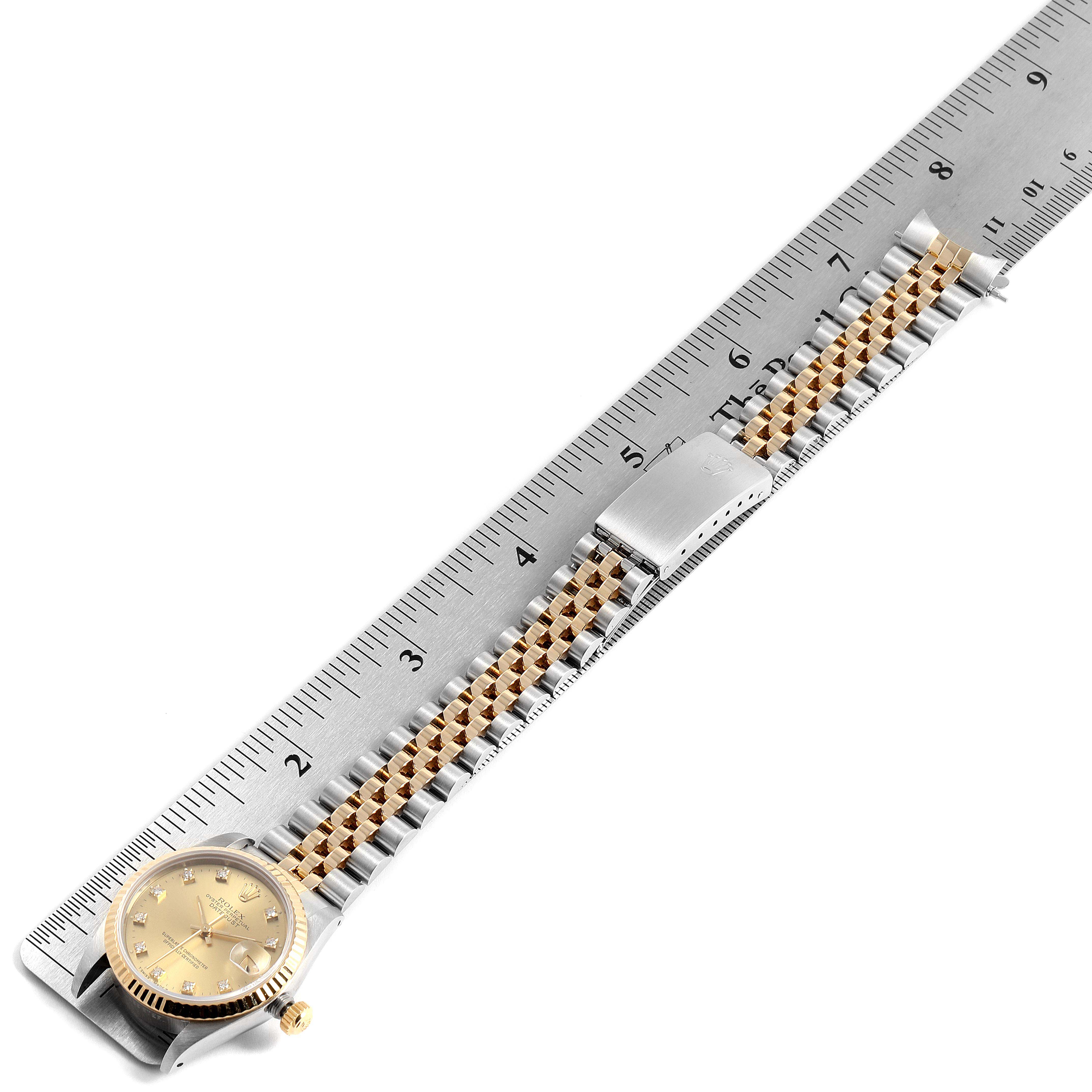 The Rolex Mid-Size 68273 Women
s Steel and Gold (two tone) Champagne Dial 68273 Women
s Steel and Gold (two tone) Champagne Dial watch is shown angled from above, displaying the face, bracelet, and part of a ruler for scale.