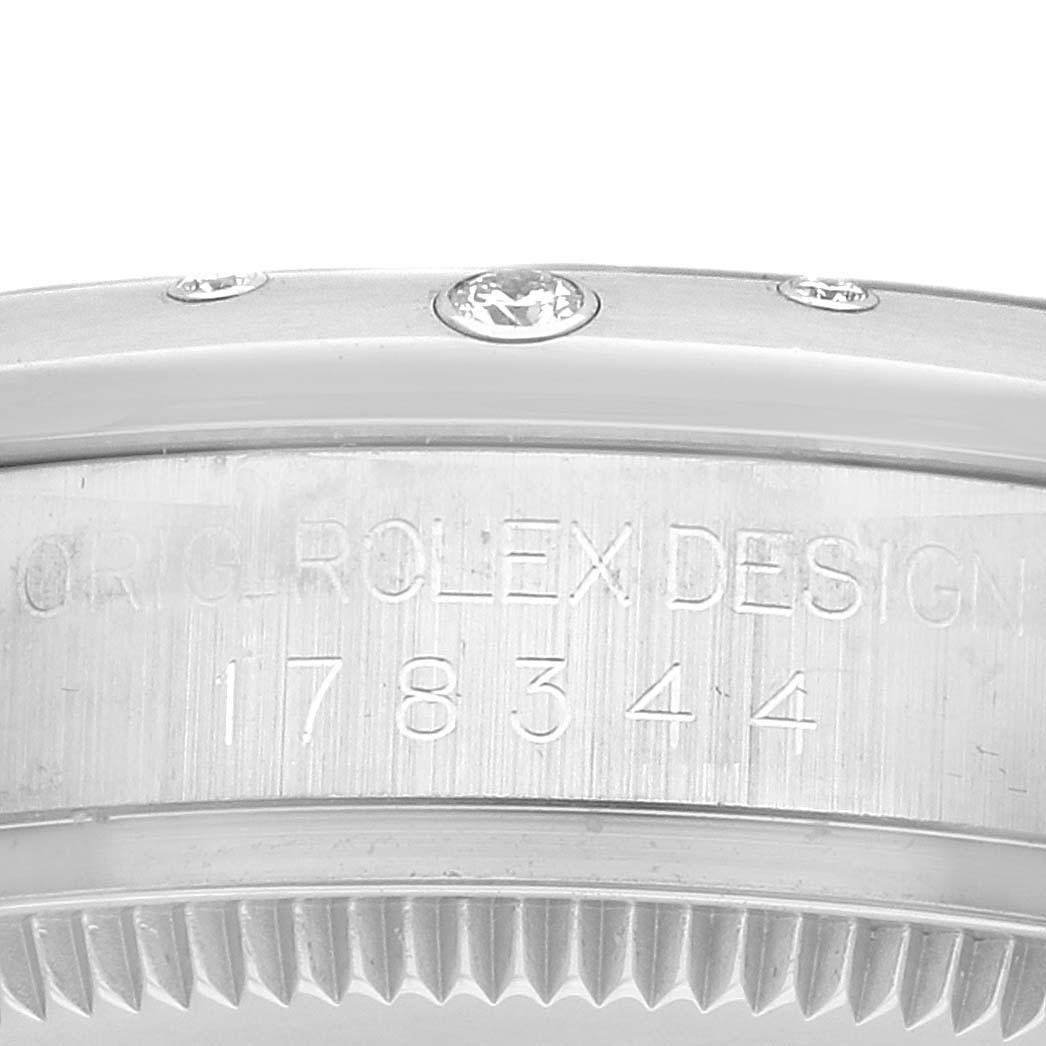 The image shows the side view of a Rolex Mid-Size 178344 Women
s Stainless Steel Blue Dial model, highlighting the engraved serial number and part of the diamond-set bezel.