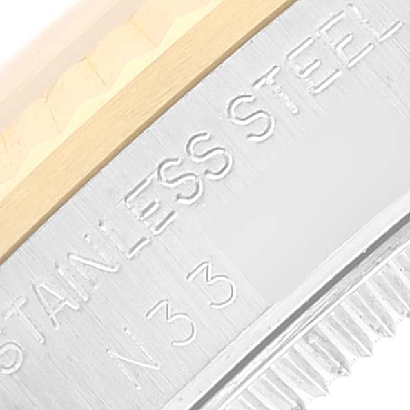 This close-up image shows the edge of the bezel and case of a Rolex Mid-Size 68273 Women's Steel and Gold (two tone) Blue Dial 68273 Women's Steel and Gold (two tone) Blue Dial watch, highlighting the "STAINLESS STEEL" engraving.