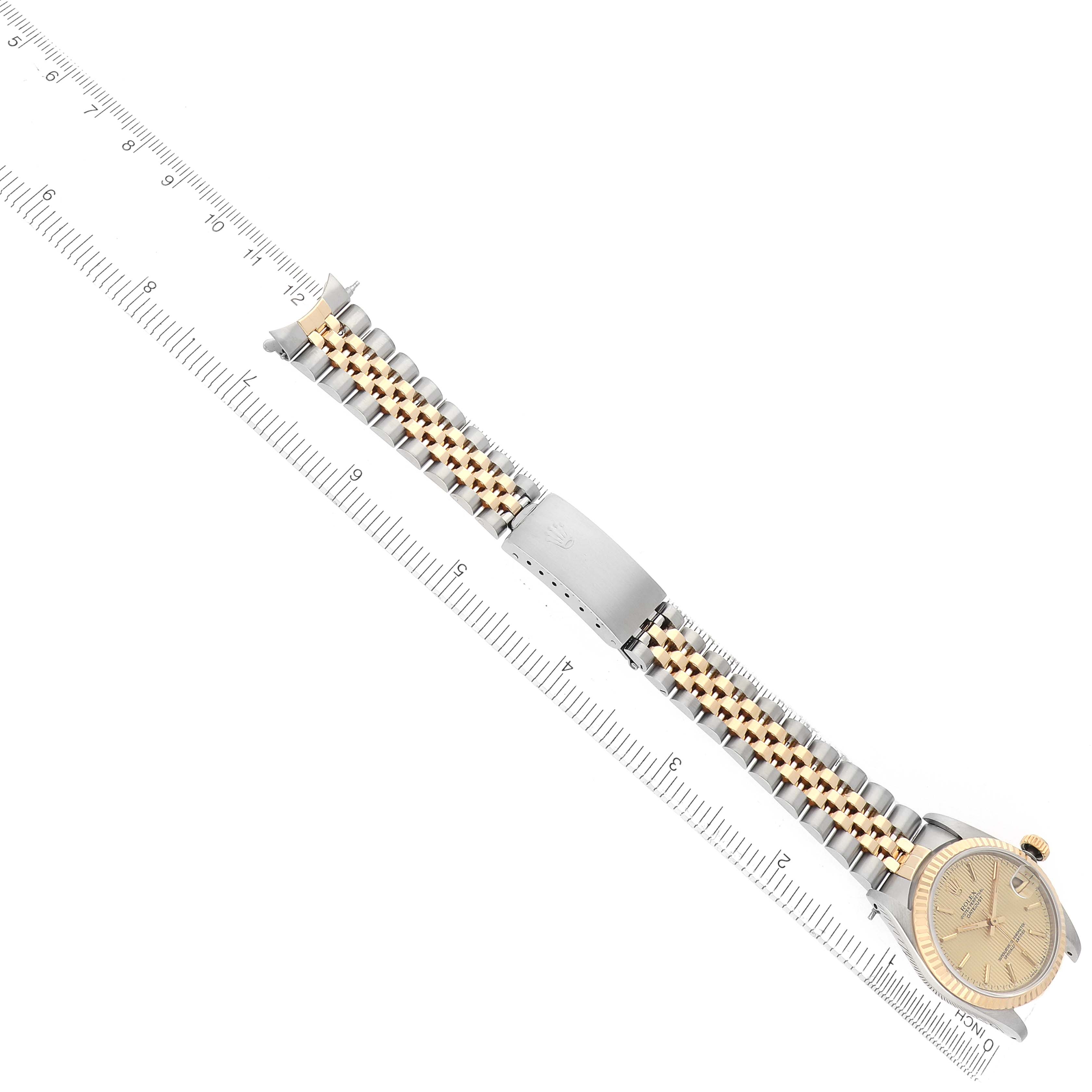 The Rolex Mid-Size 68273 Women
s Steel and Gold (two tone) Champagne Dial watch is displayed diagonally, showing the bracelet, clasp, and partial face with a ruler for scale.