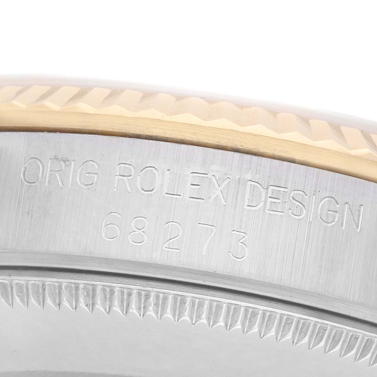 The image shows a close-up angle of the Rolex Mid-Size 68273 Women
s Steel and Gold (two tone) Champagne Dial model
s bezel and case side engraving with the design number.