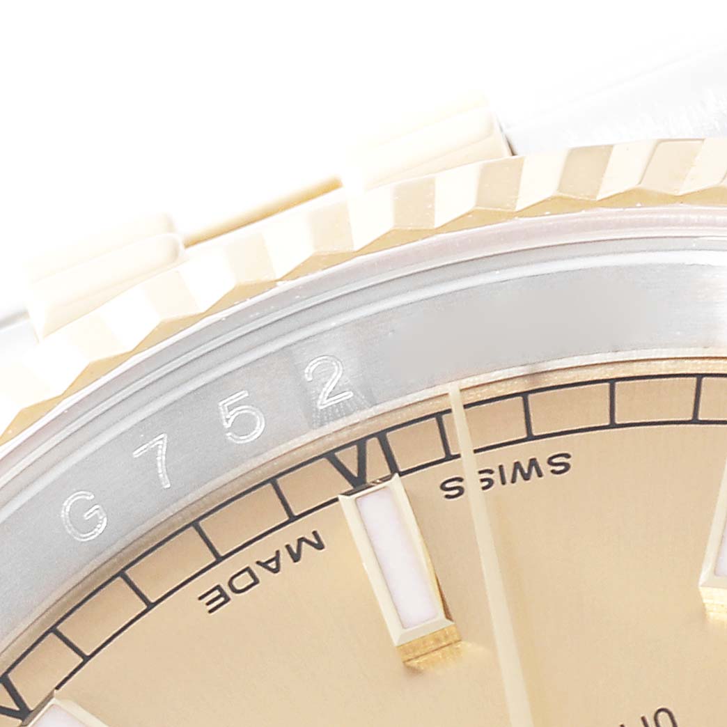 This close-up of the Rolex Datejust 116233 Men's Steel and Gold (two tone) Champagne Dial 116233 Men's Steel and Gold (two tone) Champagne Dial watch shows part of the fluted bezel and a section of the dial.
