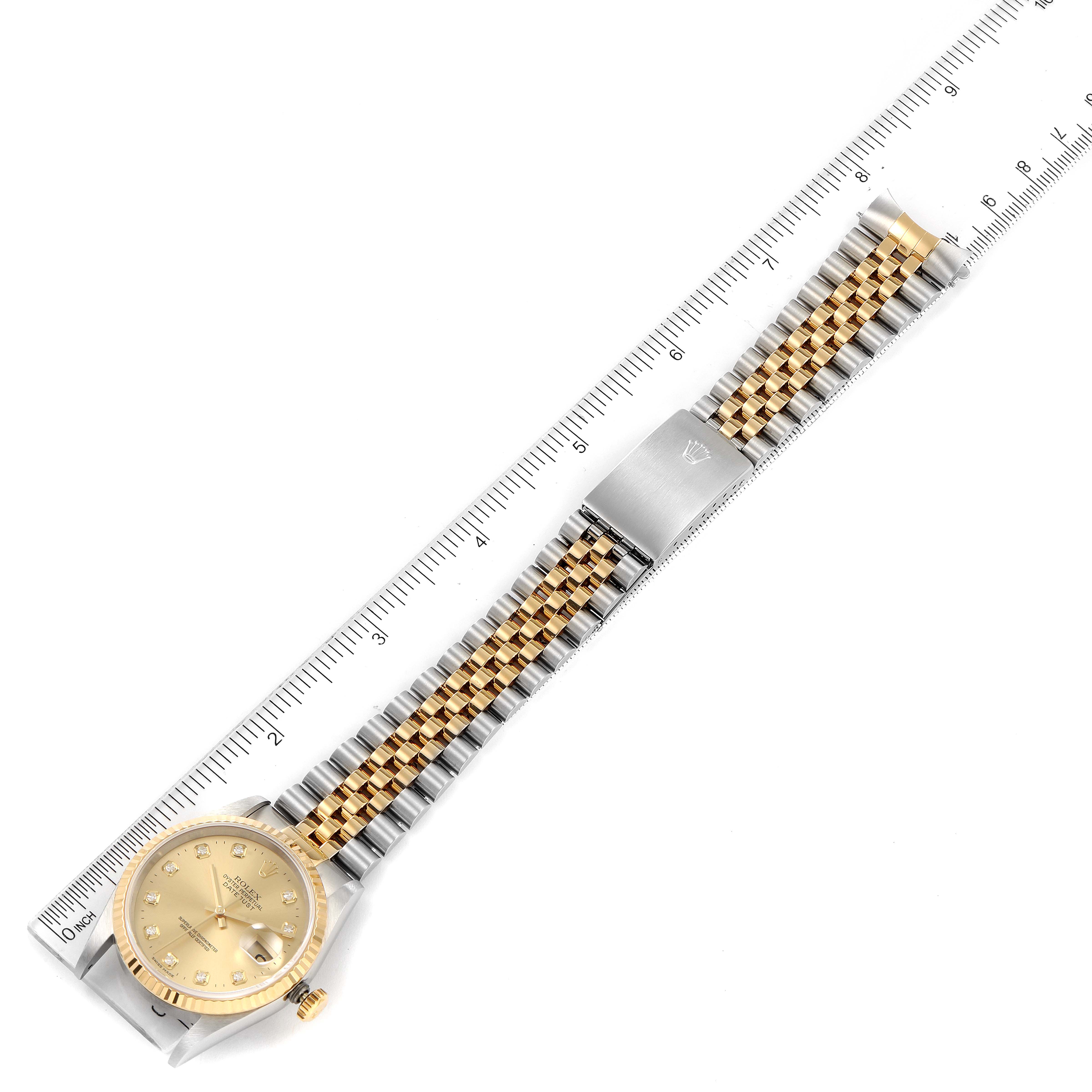The image shows a top-down view of a Rolex Datejust 16233 Men's Steel and Gold (two tone) Champagne Dial 16233 Men's Steel and Gold (two tone) Champagne Dial watch, featuring the dial and the two-tone bracelet with a ruler for scale.