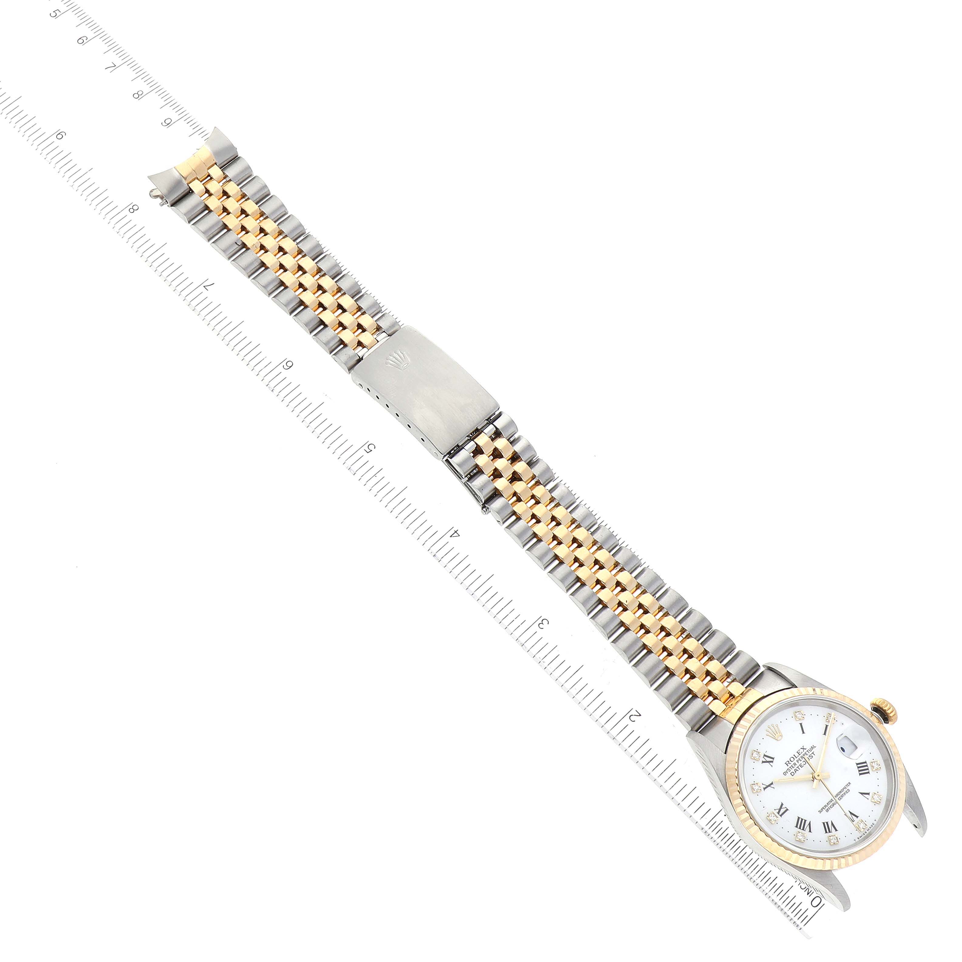 The Rolex Datejust 16233 Men's Steel and Gold (two tone) White Dial 16233 Men's Steel and Gold (two tone) White Dial watch is shown fully extended, at a slight angle, with both the face and band visible, next to a ruler.